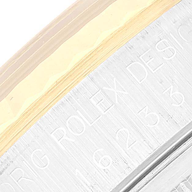 This image shows a close-up of the engraved outer rim of a Rolex Datejust 16233 Men's Steel and Gold (two tone) Black Dial 16233 Men's Steel and Gold (two tone) Black Dial watch.