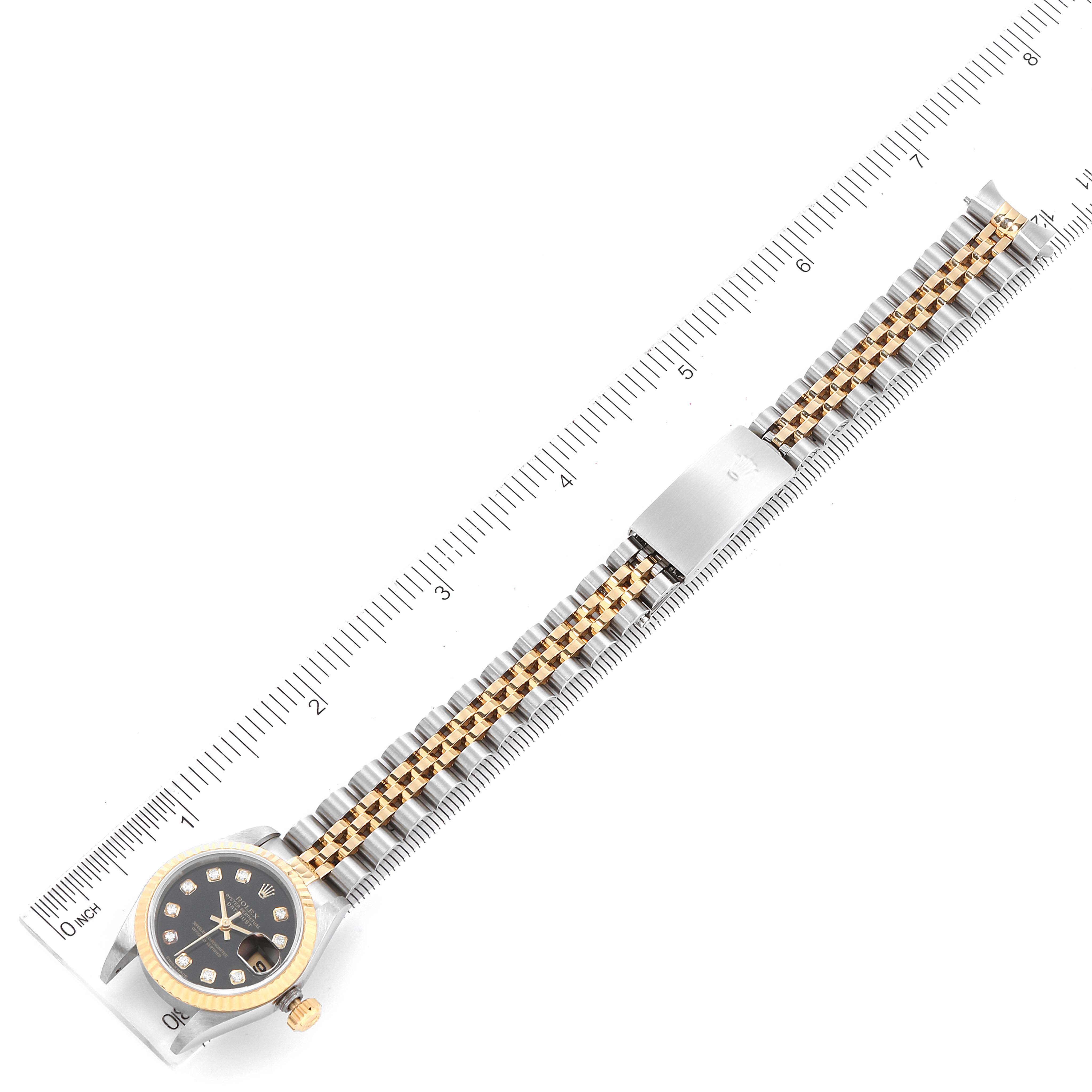 The image shows a Rolex Datejust 79173 Women's Steel and Gold (two tone) Black Dial 79173 Women's Steel and Gold (two tone) Black Dial watch laid flat, with its black dial, gold bezel, and two-tone bracelet fully visible.