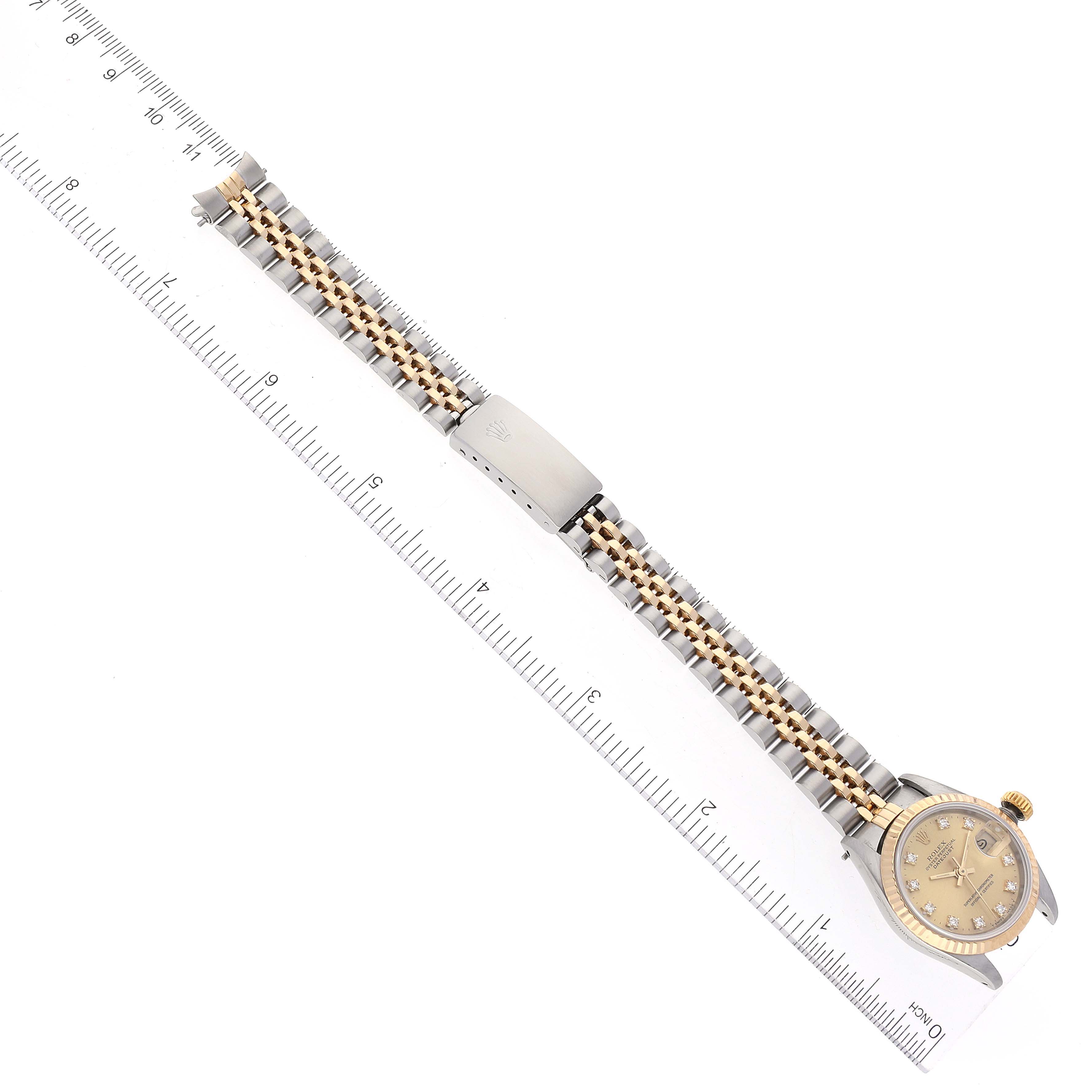 The image shows a Rolex Datejust 69173 Women's Steel and Gold (two tone) Champagne Dial 69173 Women's Steel and Gold (two tone) Champagne Dial watch laid flat with a ruler for scale, showcasing the dial, crown, and two-tone bracelet.