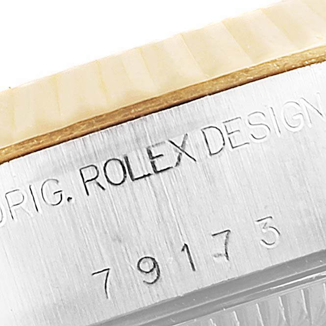 Close-up of the Rolex Datejust 79173 Women's Steel and Gold (two tone) Black Dial 79173 Women's Steel and Gold (two tone) Black Dial watch case, showcasing the engraved branding and serial number.