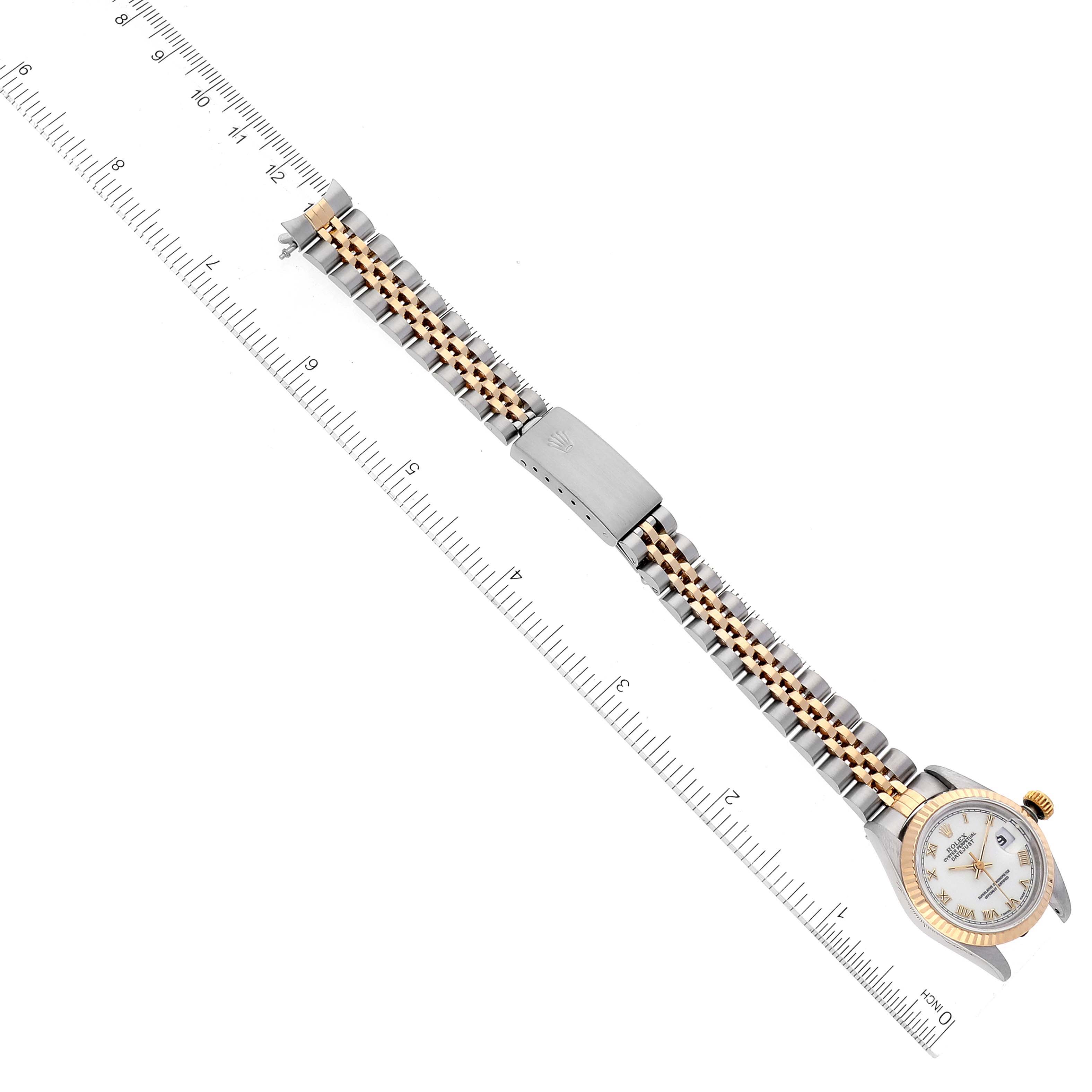 The image shows a top view of the entire Rolex Datejust 69173 Women's Steel and Gold (two tone) White Dial 69173 Women's Steel and Gold (two tone) White Dial watch, including its face and two-tone metal band next to a ruler for scale.