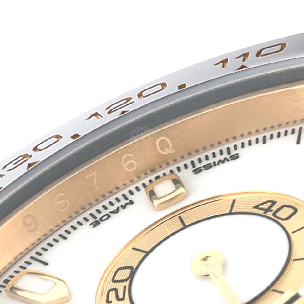 This close-up image of a Rolex Daytona 116518 Men's Yellow Gold White Dial 116518 Men's Yellow Gold White Dial watch shows details of the bezel and the edge of the dial.