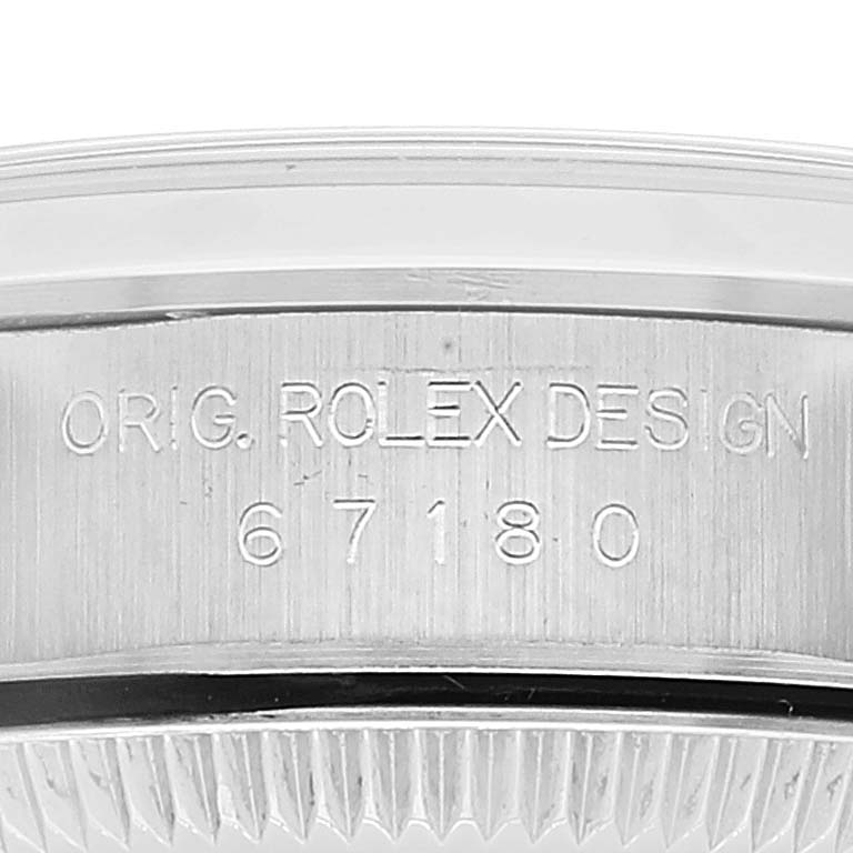 The image shows a close-up of the case side of a Rolex Oyster Perpetual 67180 Women
s Stainless Steel Pink Dial 67180 Women
s Stainless Steel Pink Dial watch, clearly displaying the engraved model number "67180".