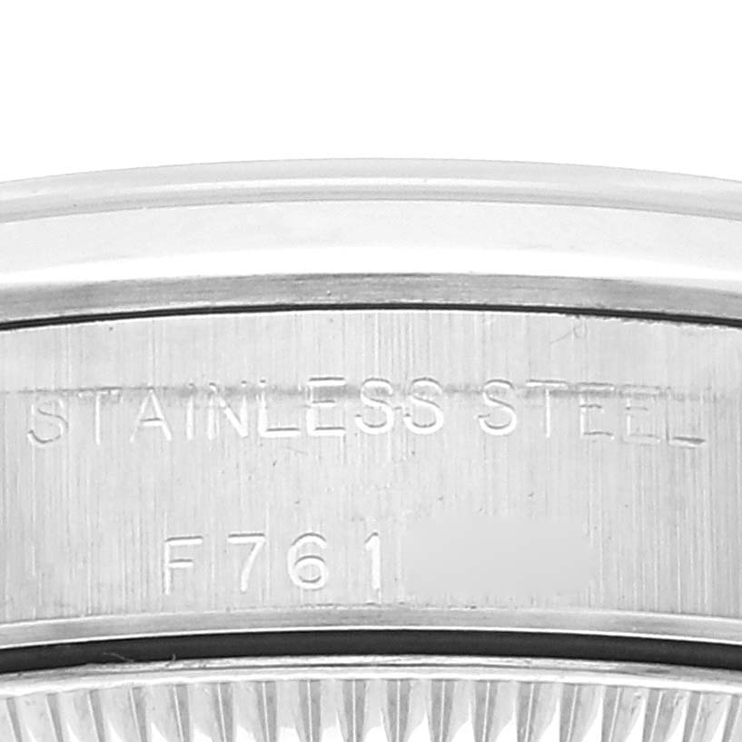 The image shows the bezel and part of the case back of a Rolex Oyster Perpetual 76080 Women
s Stainless Steel Pink Dial 76080 Women
s Stainless Steel Pink Dial watch with "STAINLESS STEEL" engraved.