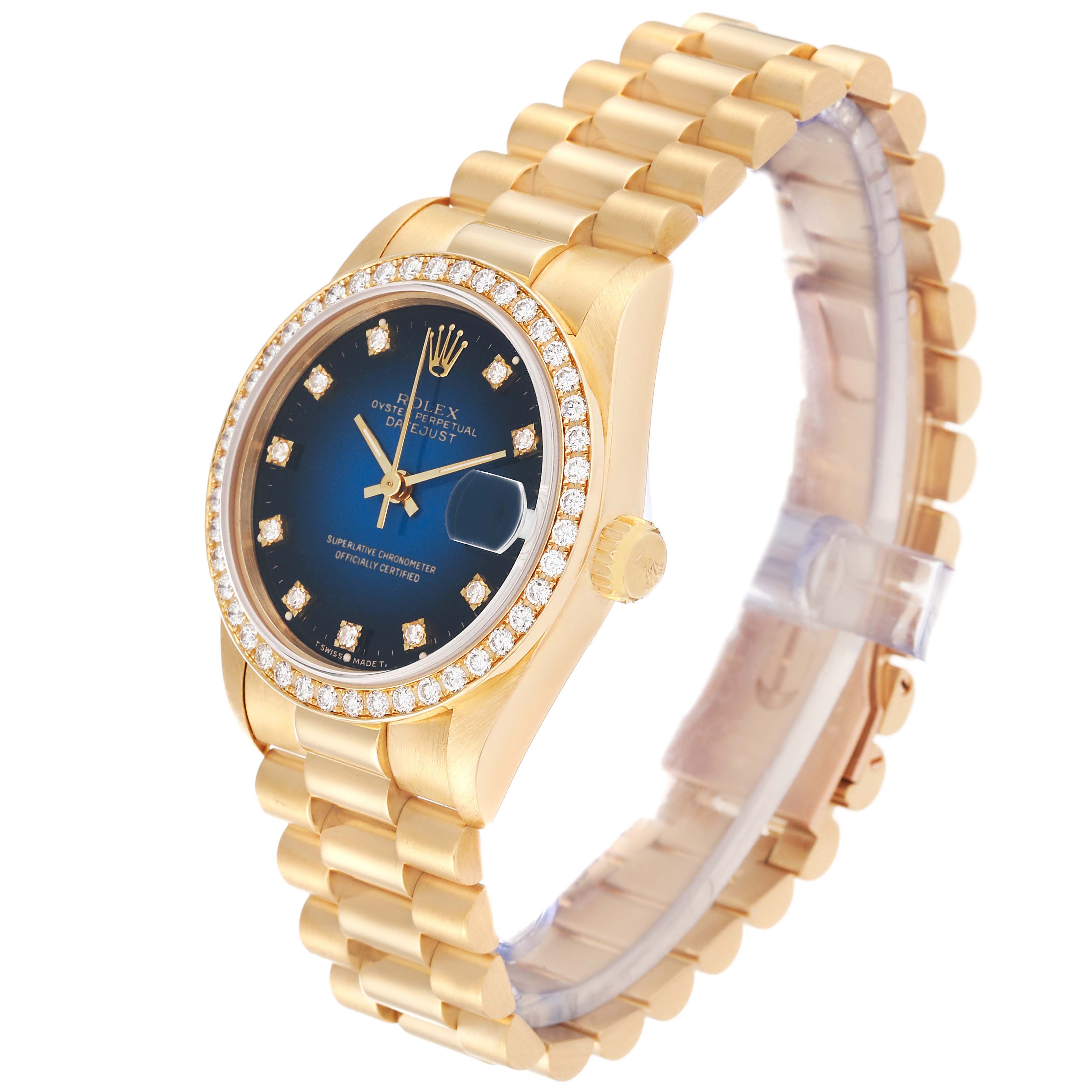 The President model Rolex watch is shown at an angle revealing the diamond-studded bezel, blue dial, and gold bracelet.