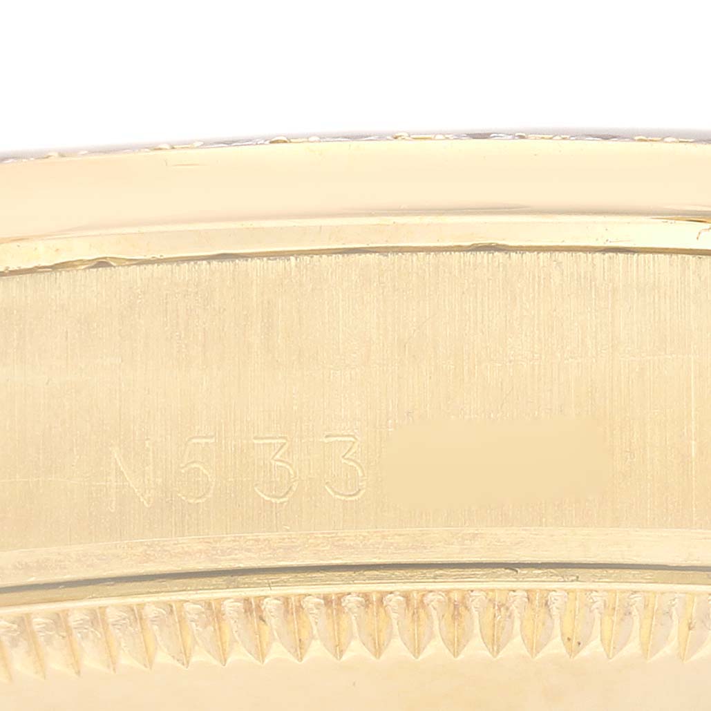 This image shows a close-up of the case side and bezel teeth of a Rolex President 68288 Women's Yellow Gold Blue Dial 68288 Women's Yellow Gold Blue Dial model watch, focusing on its engraving.