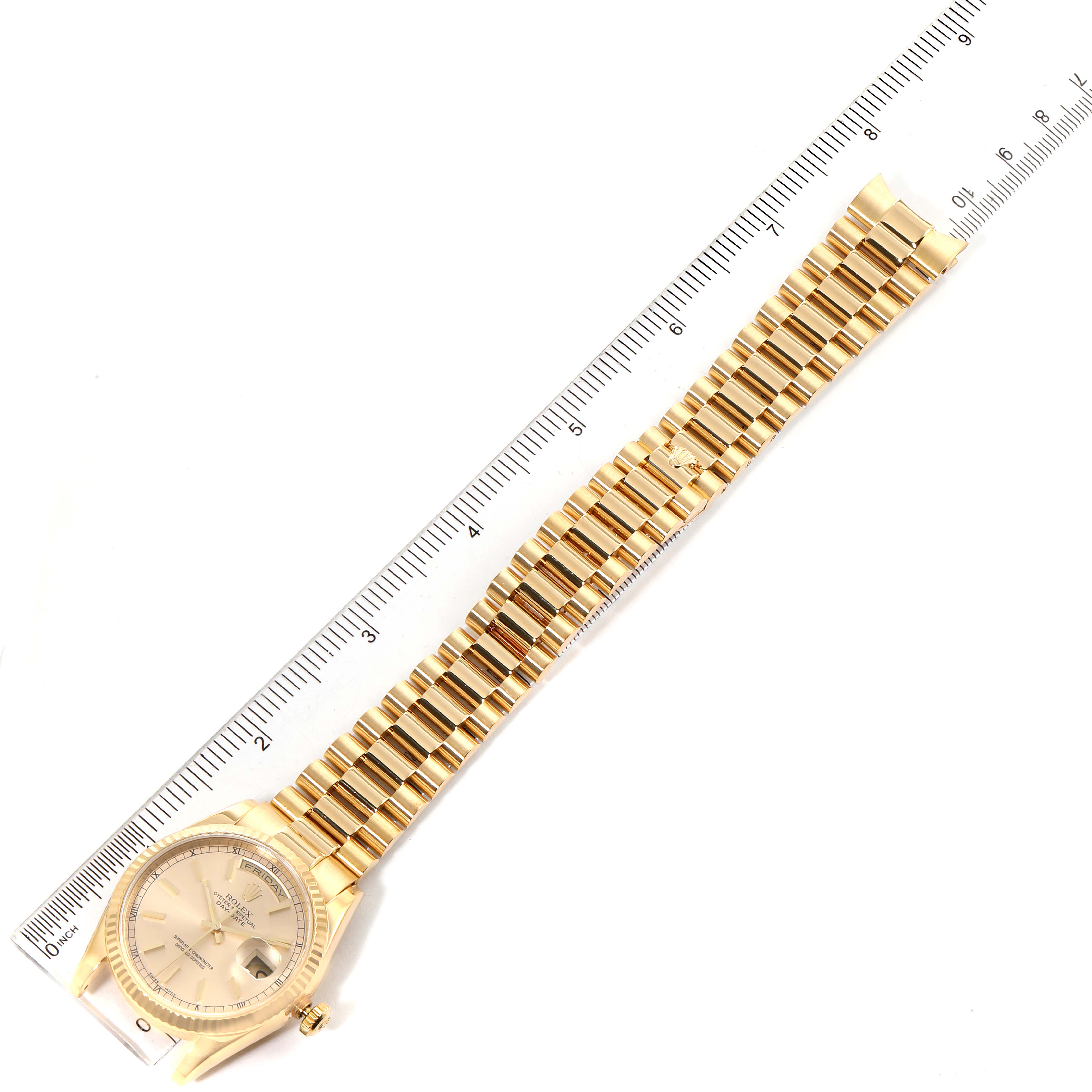 The image shows a Rolex President 118238 Men
s Yellow Gold Champagne Dial 118238 Men
s Yellow Gold Champagne Dial model watch, featuring the face and full length of the gold band next to a ruler.