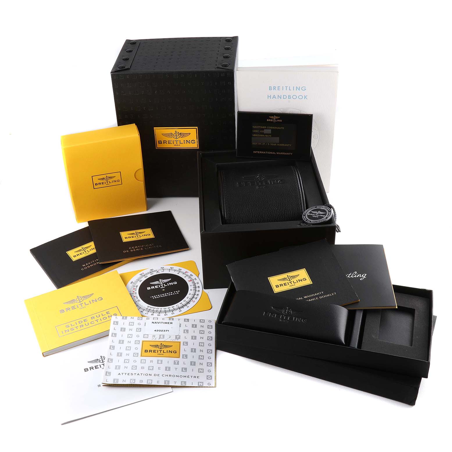 The image shows an unboxing of a Breitling Limited Series watch with various booklets, manuals, and protective packaging.