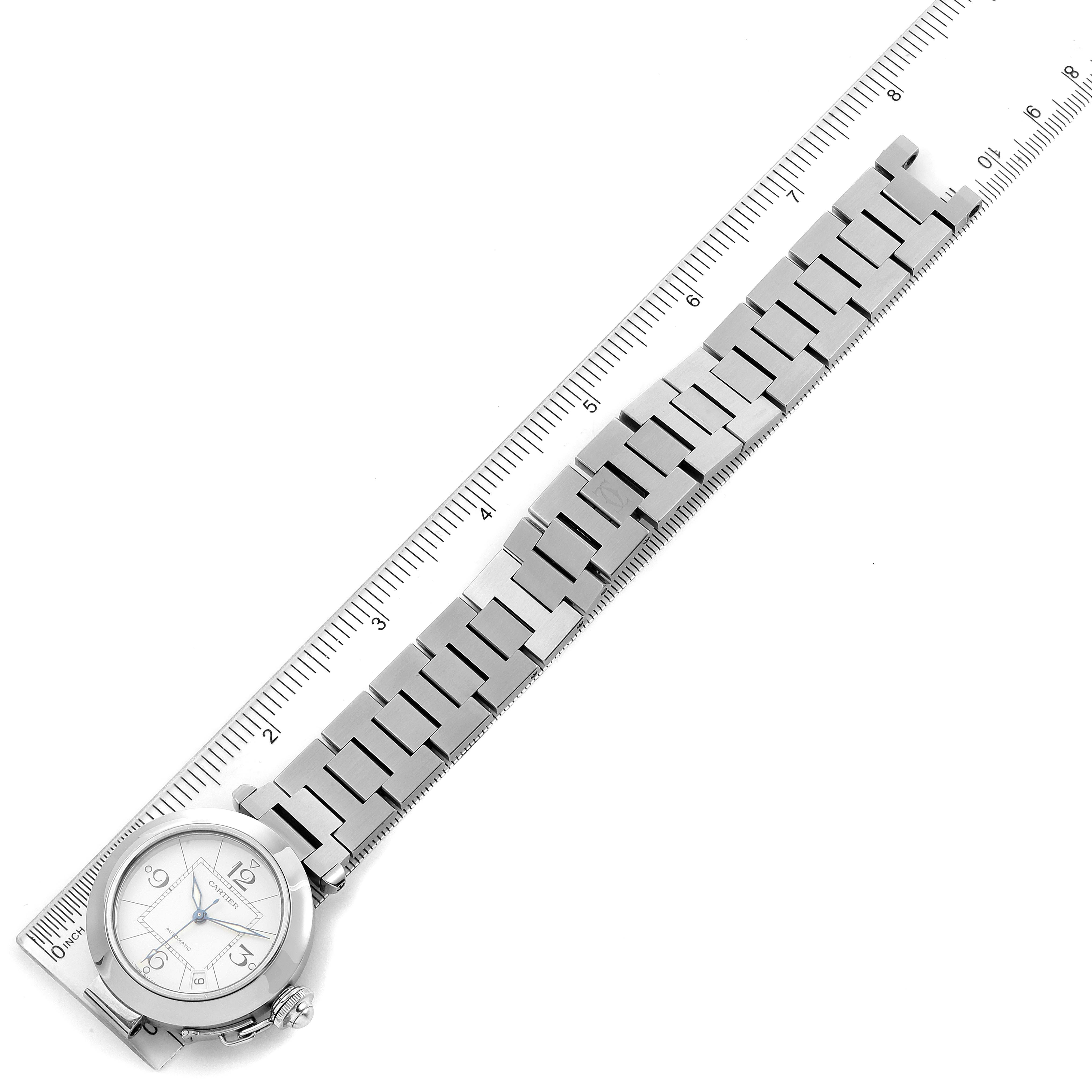 This image shows the Cartier Pasha W31074M7 Men's Stainless Steel White Dial W31074M7 Men's Stainless Steel White Dial watch laid flat with its full metal bracelet next to a ruler for scale.