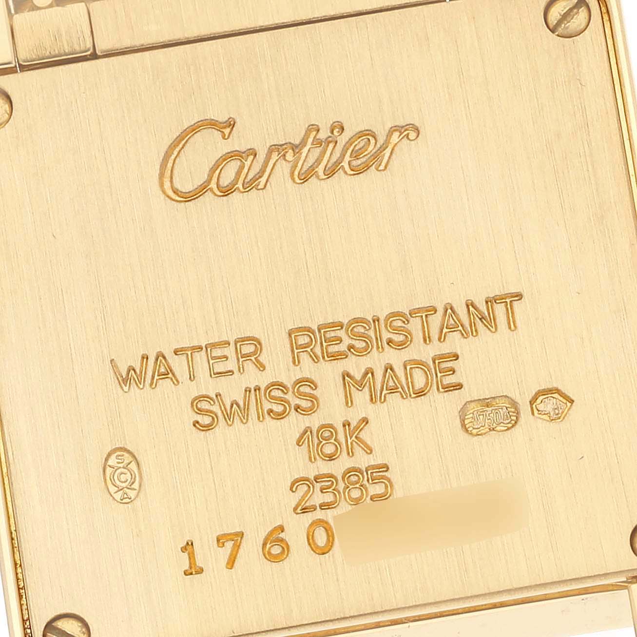 This image shows the back case of a Cartier Tank Française watch, displaying engravings and hallmarks.