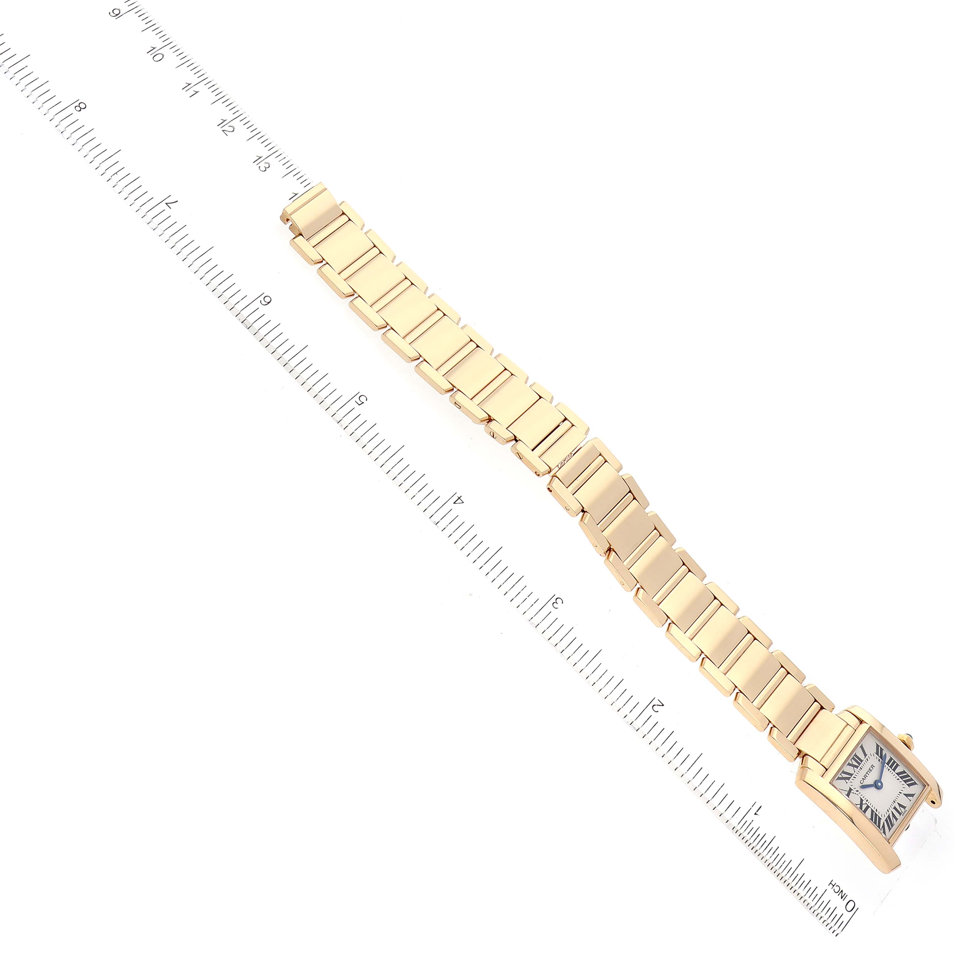 The image shows a Cartier Tank Française watch laid flat alongside a ruler, highlighting the watch's face and bracelet.