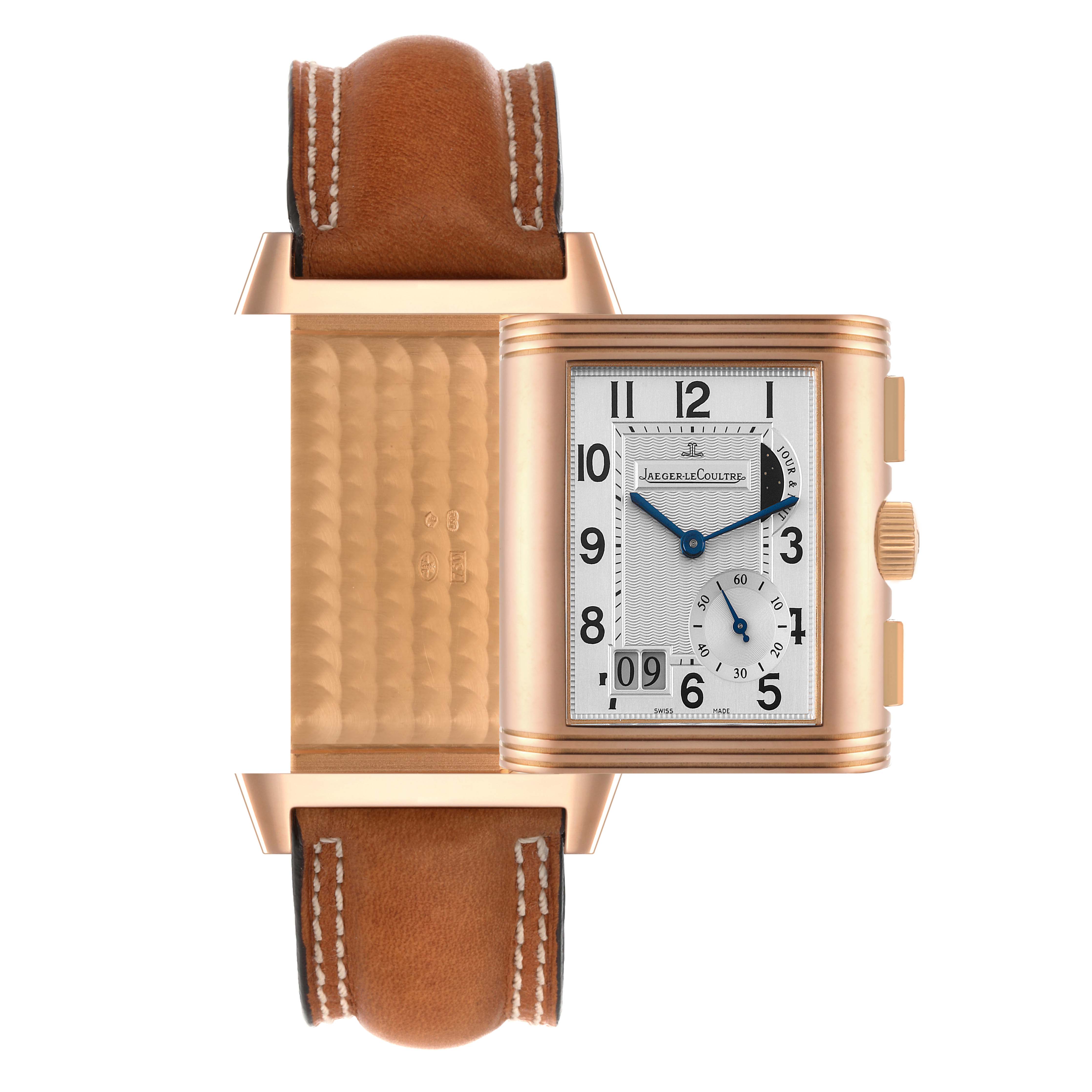 The image shows the Jaeger-LeCoultre Reverso watch with its face pivoted to reveal the gold-patterned back and a tan leather strap.