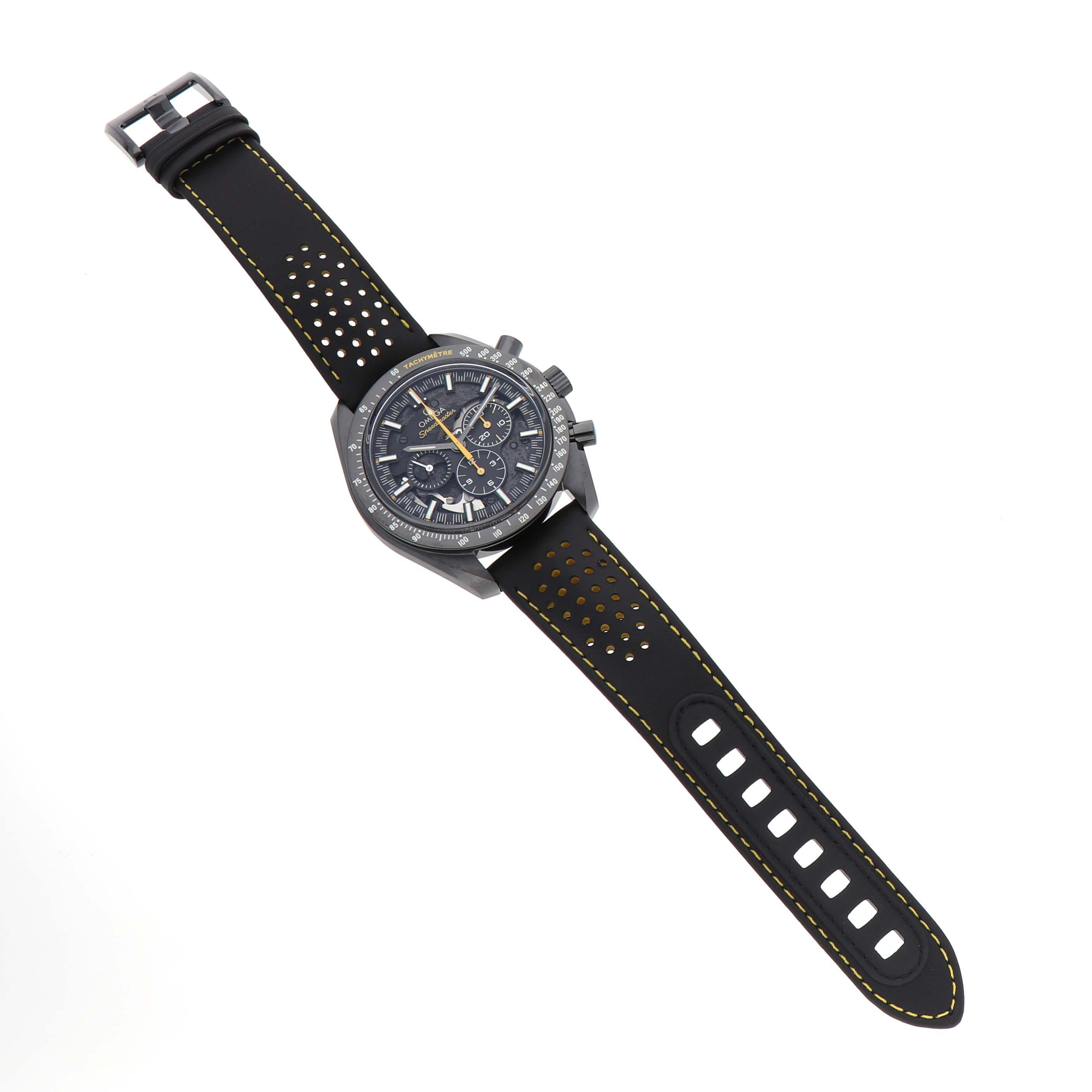The image shows an Omega Speedmaster 311.92.44.30.01.001 Men's Ceramic Black Dial watch from a top-down angle, highlighting its face, bezel, and perforated strap.