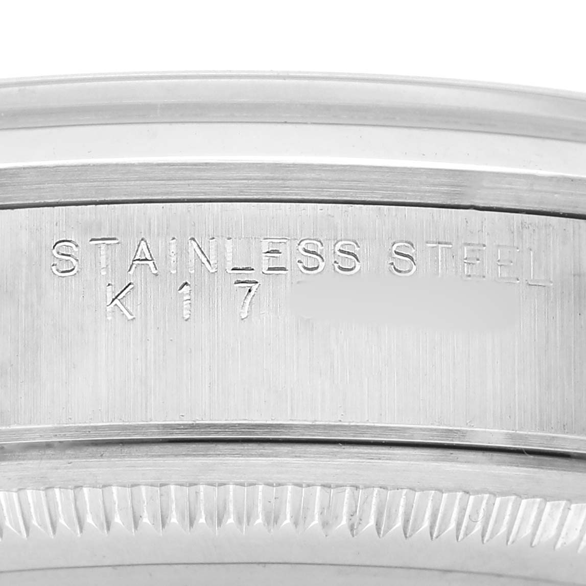 The image shows a close-up of the stainless steel casing of a Rolex Air-King 14000M Men's Stainless Steel Silver Dial watch, highlighting engraved details.