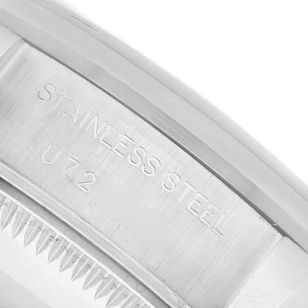 The image shows a close-up side view of the Rolex Date 69160 Women's Stainless Steel Blue Dial 69160 Women's Stainless Steel Blue Dial model, focusing on the stainless steel case with inscriptions.