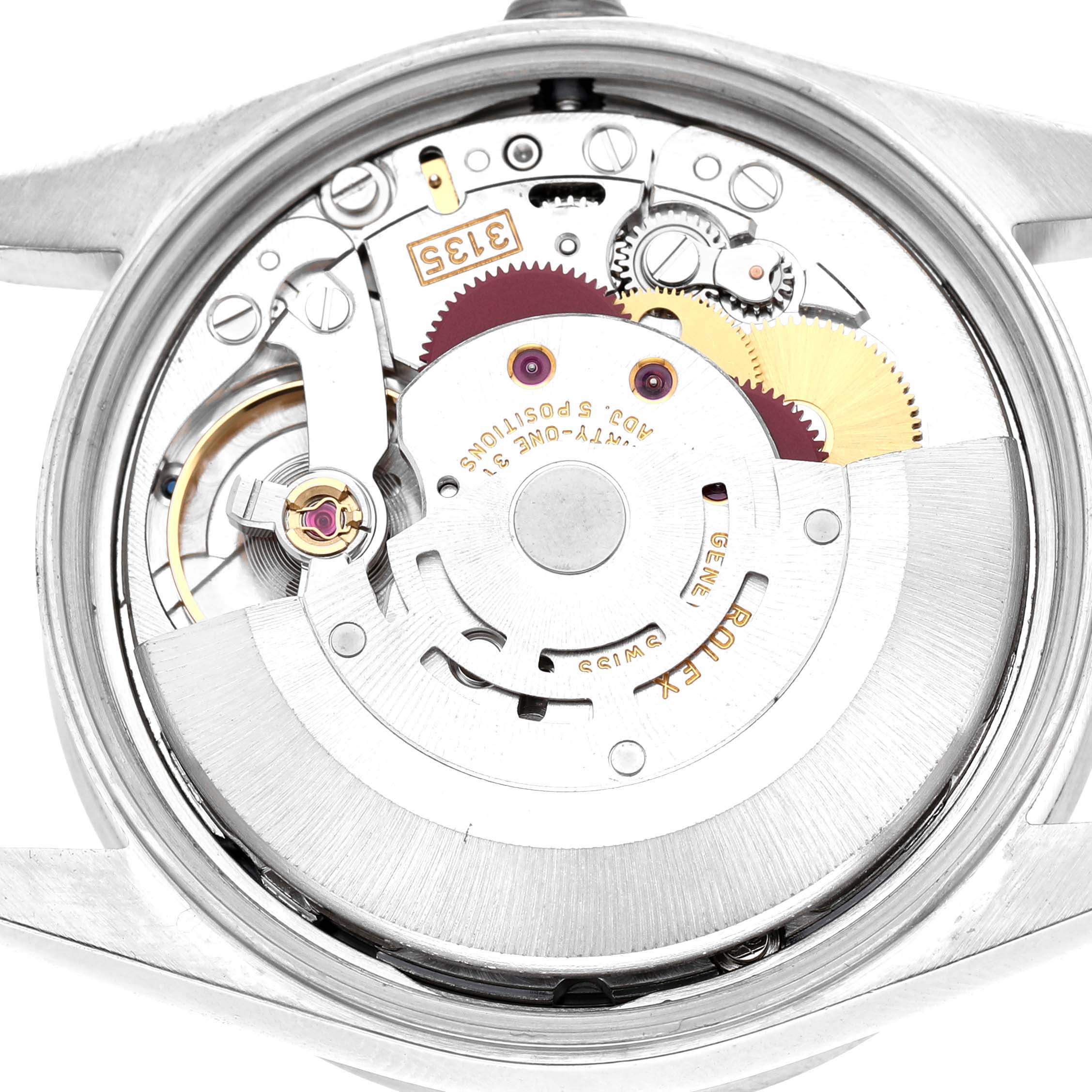 The image shows the movement of a Rolex Date 15210 Men's Stainless Steel Blue Dial model, viewed from the back with gears and components visible.