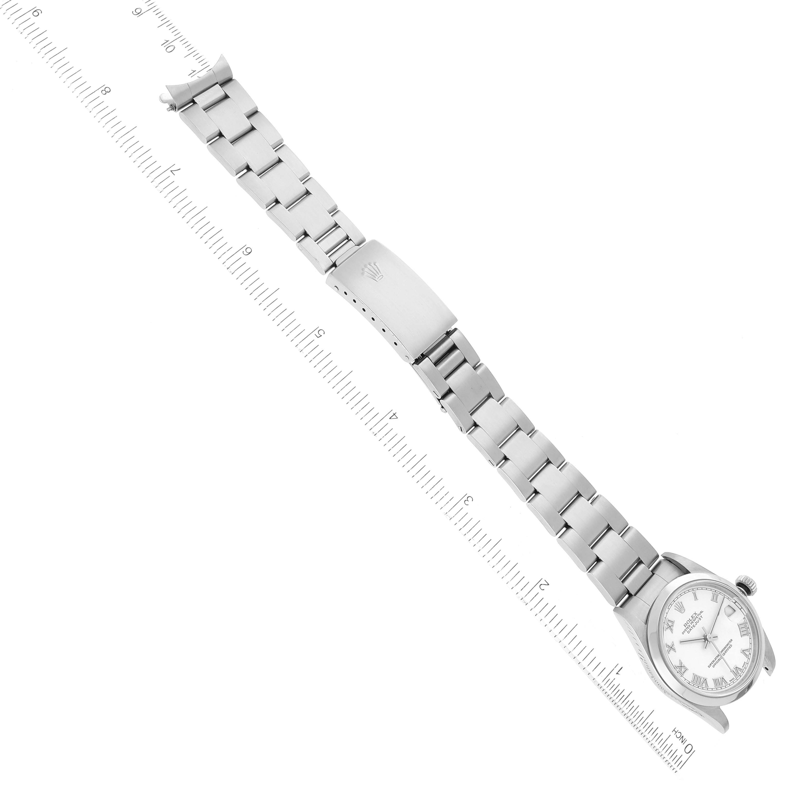 The Rolex Mid-Size 78240 Women
s Stainless Steel White Dial 78240 Women
s Stainless Steel White Dial watch is shown from a top-down angle, highlighting its face, band, and clasp alongside a measuring scale.