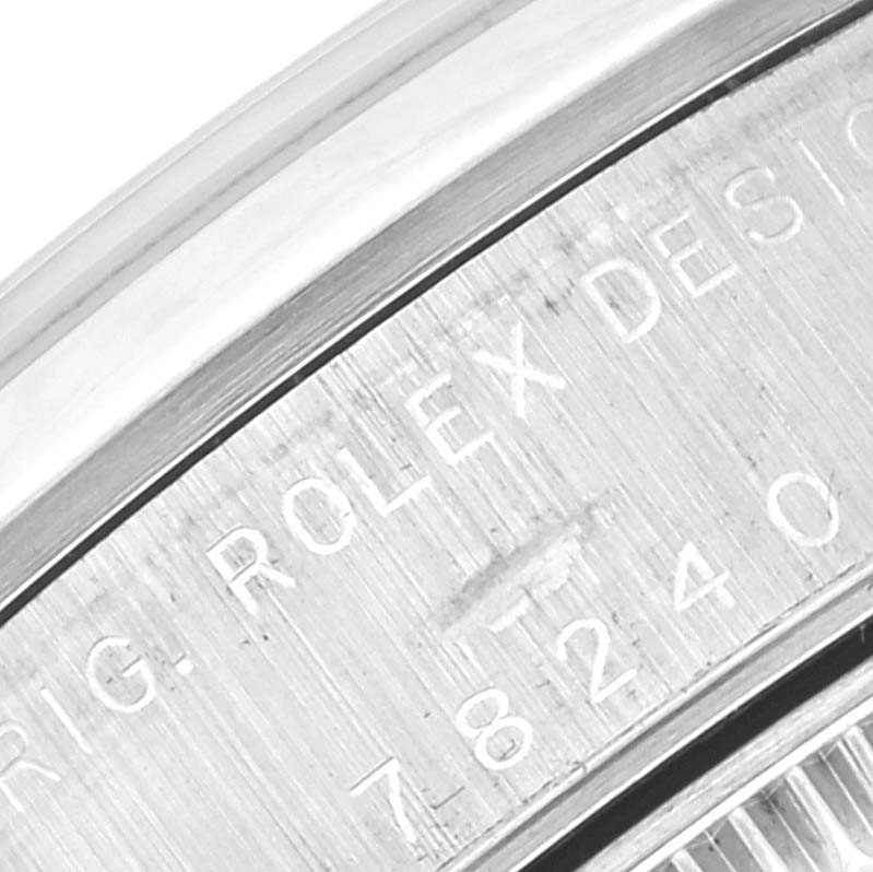 The image shows an angled close-up of the engraved text and serial number on the caseback of a Rolex Mid-Size 78240 Women
s Stainless Steel White Dial 78240 Women
s Stainless Steel White Dial model watch.