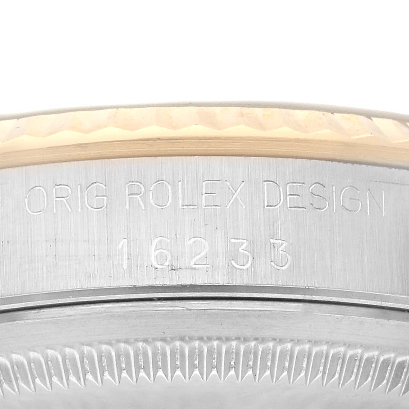 The image shows a close-up of the side of a Rolex Datejust 16233 Men's Steel and Gold (two tone) Champagne Dial 16233 Men's Steel and Gold (two tone) Champagne Dial model, displaying the engraved text and part of the fluted bezel.