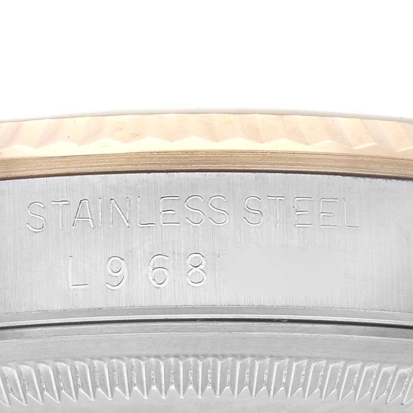 Close-up of the casing edge of a Rolex Datejust 16233 Men's Steel and Gold (two tone) Champagne Dial 16233 Men's Steel and Gold (two tone) Champagne Dial watch, showing the engraved "STAINLESS STEEL" and serial number.