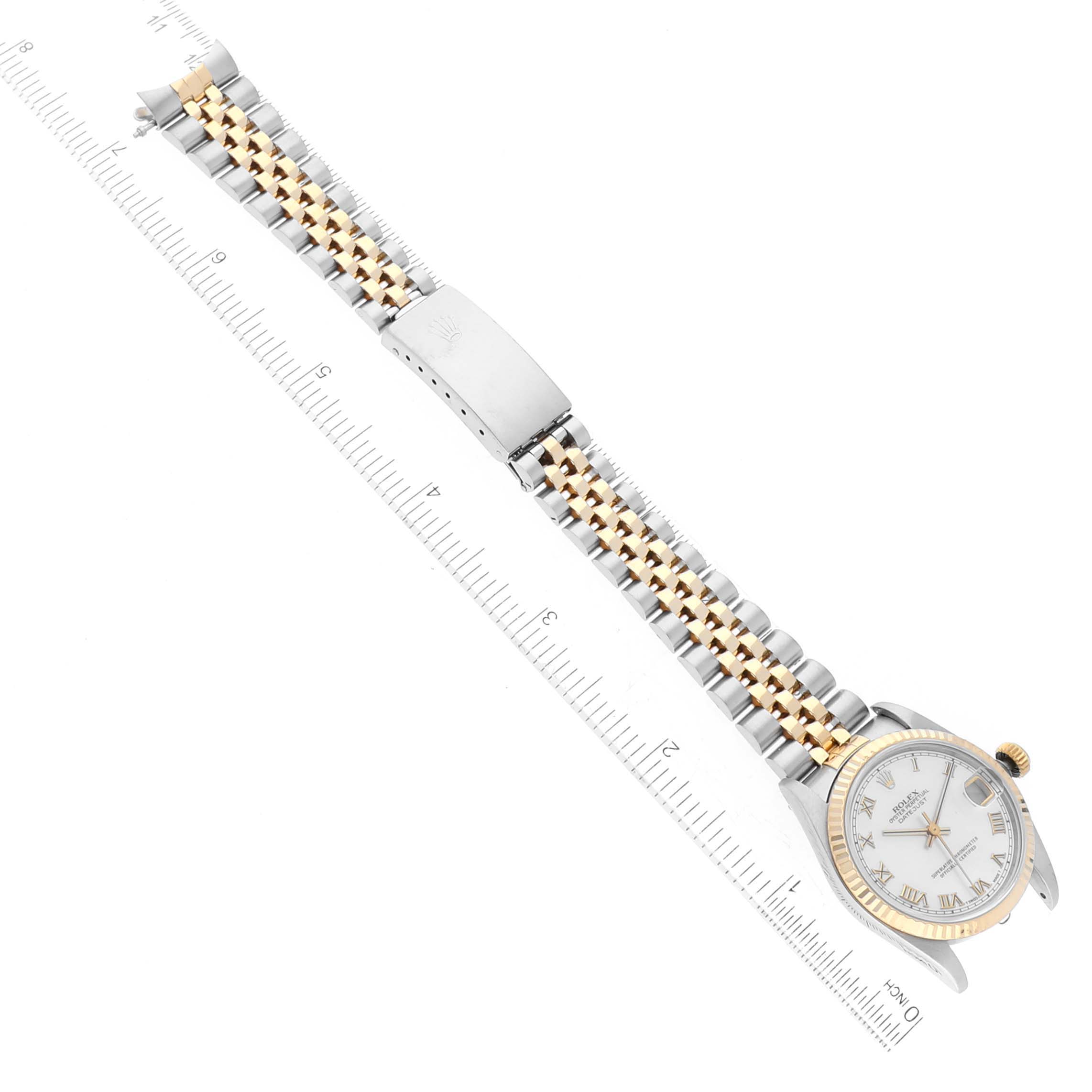 The image shows a Mid-Size Rolex watch lying flat with its full bracelet, clasp, case, and bezel, alongside a ruler for scale.