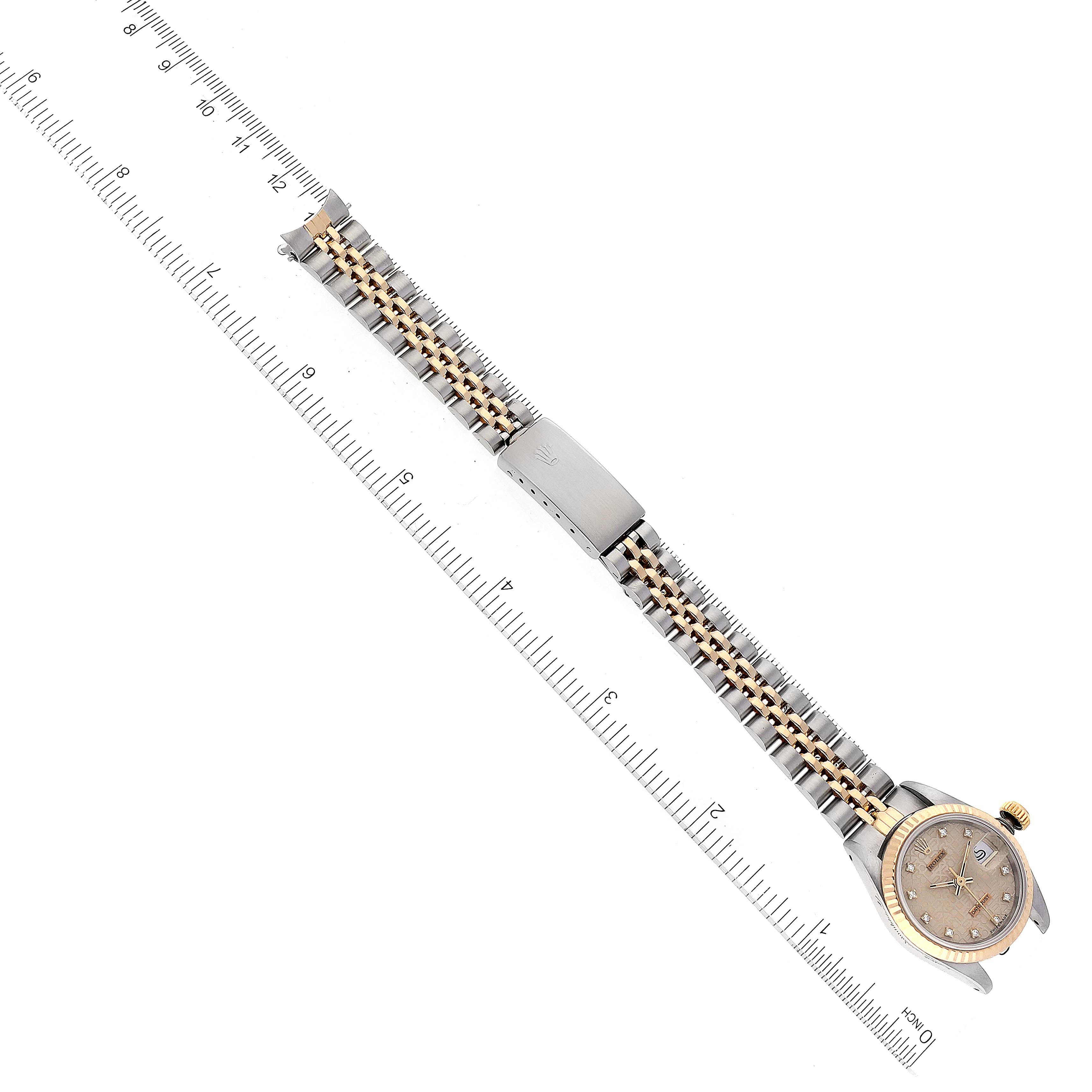 The image shows a top-down view of a Rolex Datejust 69173 Women's Steel and Gold (two tone) Silver Dial 69173 Women's Steel and Gold (two tone) Silver Dial watch, highlighting its face, bezel, bracelet, and clasp alongside a ruler for scale.