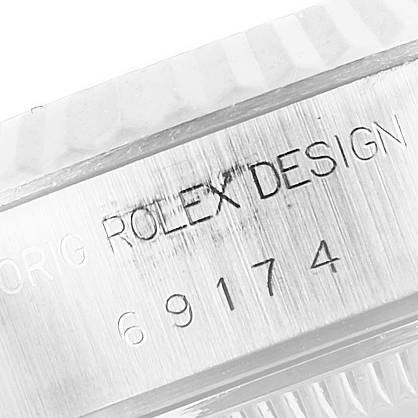 The image shows a close-up view of the engraved watch case of a Rolex Datejust 69174 Women's Stainless Steel Silver Dial 69174 Women's Stainless Steel Silver Dial model, focusing on the serial number and "Rolex Design" inscription.