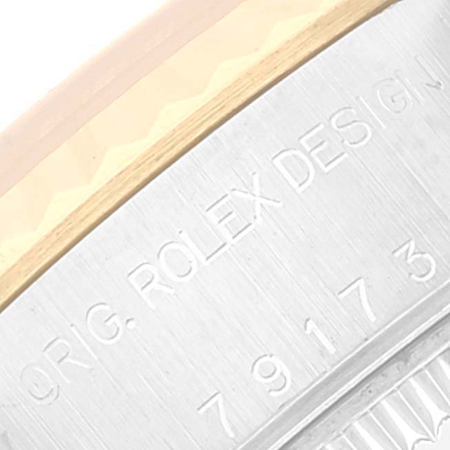 This image shows a close-up of the bezel and the engraved design on the side of a Rolex Datejust 79173 Women's Steel and Gold (two tone) Beige Dial 79173 Women's Steel and Gold (two tone) Beige Dial watch.