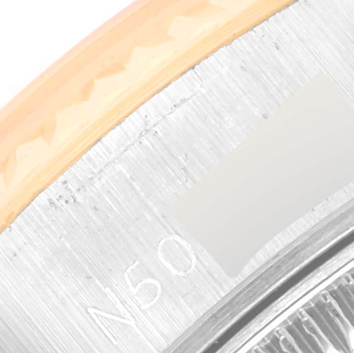 This is a close-up view of the side of the Rolex Datejust 69173 Women's Steel and Gold (two tone) White Dial 69173 Women's Steel and Gold (two tone) White Dial watch, showing part of the bezel and the engraved serial number.