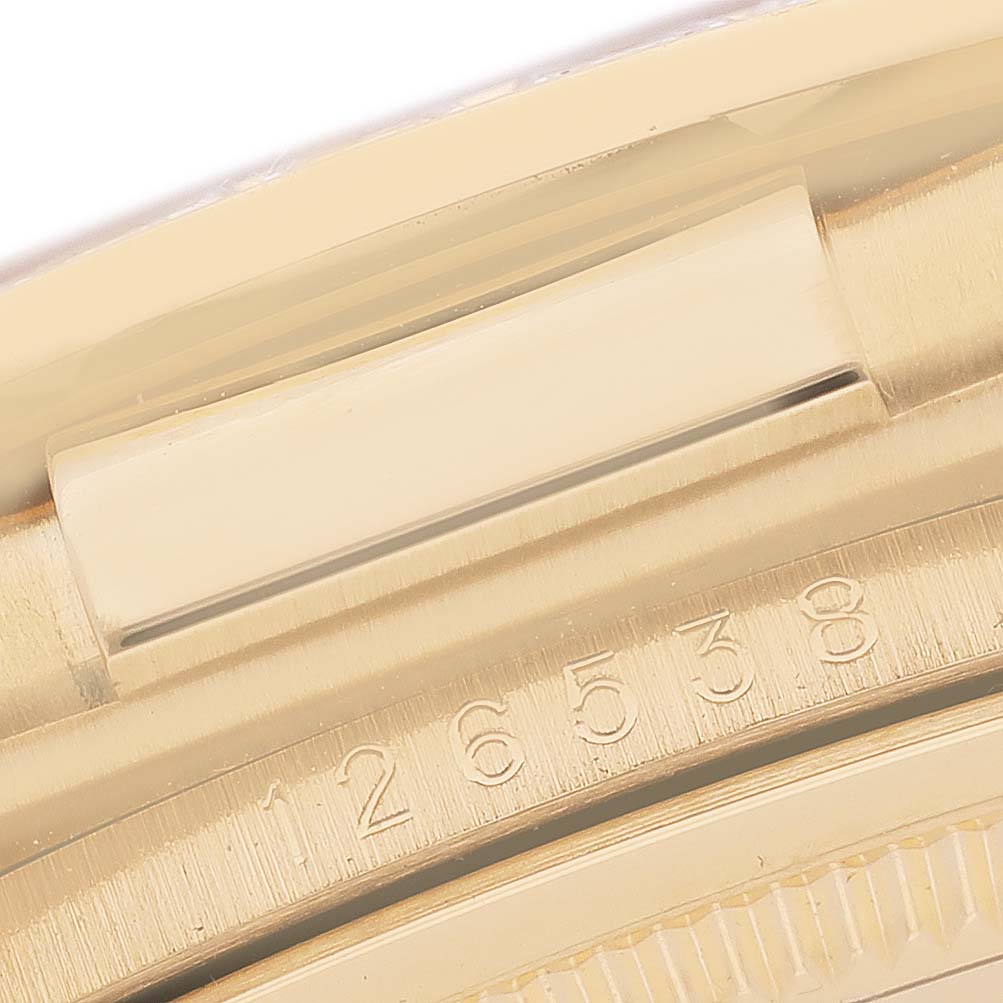 The image shows a close-up of the Rolex Daytona 126538 Men's Yellow Gold Champagne Dial's gold case with the model number engraved on the side.