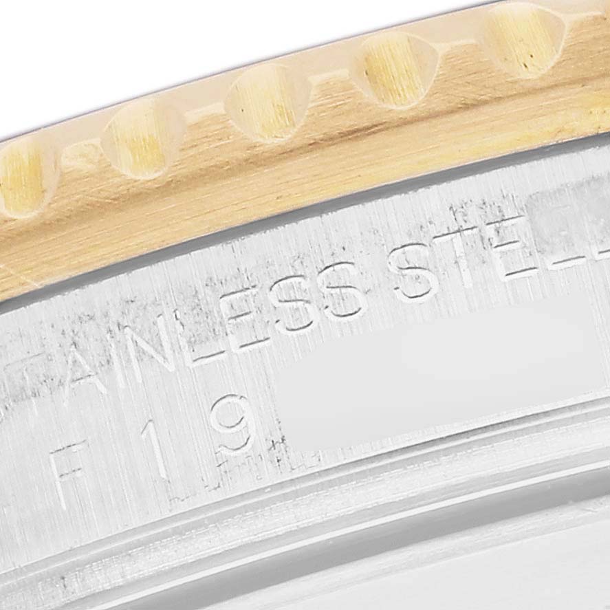 The image shows a close-up of the bezel and case edge for the Rolex GMT-Master 16713 Men
s Steel and Gold (two tone) Black Dial 16713 Men
s Steel and Gold (two tone) Black Dial, highlighting the engraved stainless steel text.