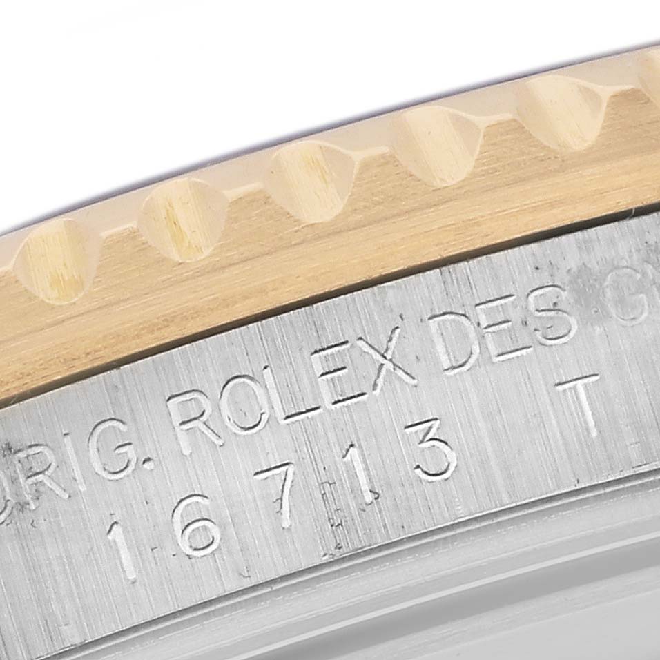 The image shows a close-up of the engraved bezel edge and the serial number of the Rolex GMT-Master 16713 Men
s Steel and Gold (two tone) Black Dial 16713 Men
s Steel and Gold (two tone) Black Dial watch.