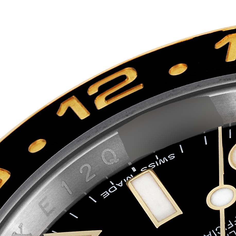 The image shows a close-up of the bezel and dial of a Rolex GMT-Master 116713 Men's Steel and Gold (two tone) Black Dial 116713 Men's Steel and Gold (two tone) Black Dial watch, focused on the "12" hour marker.