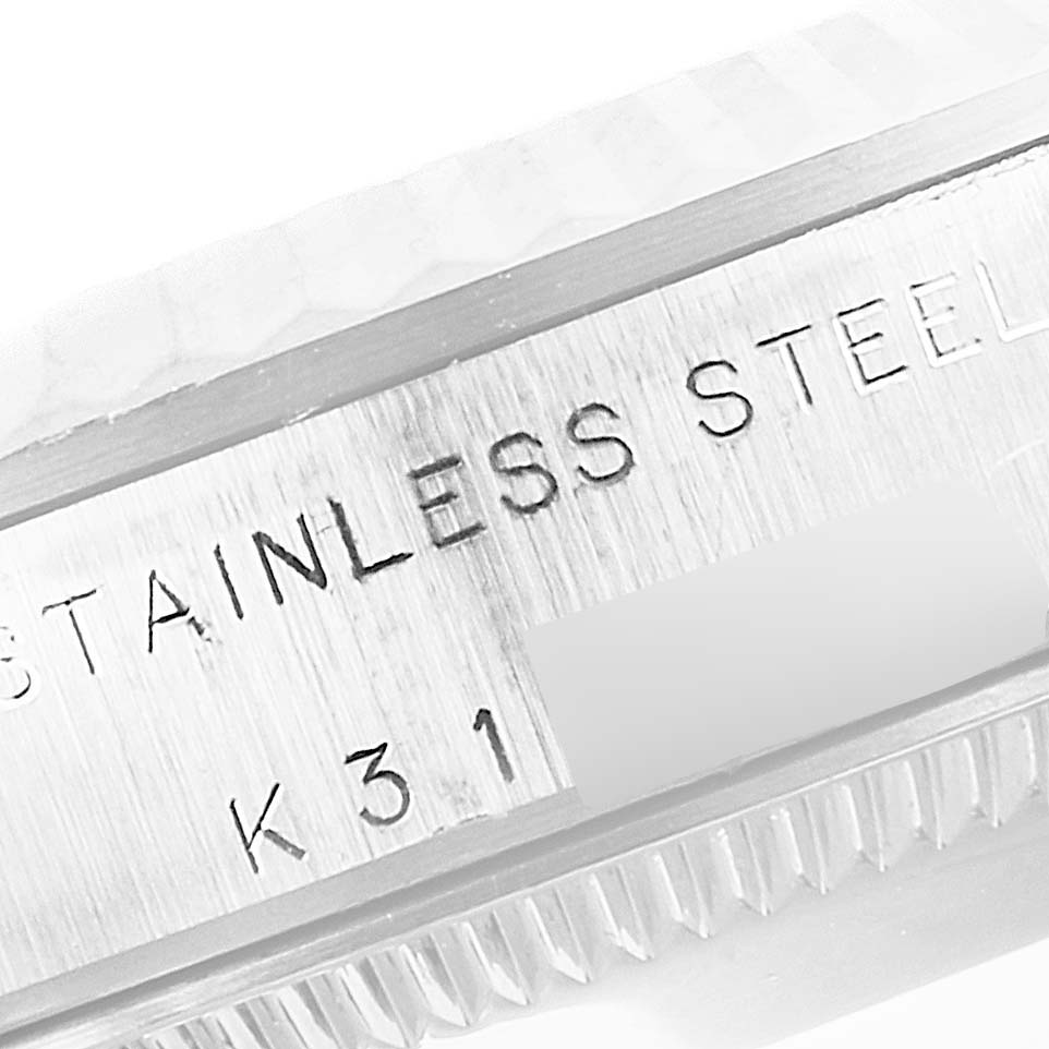 This image shows a close-up view of the stainless steel case with serial engravings on a Mid-Size Rolex watch.