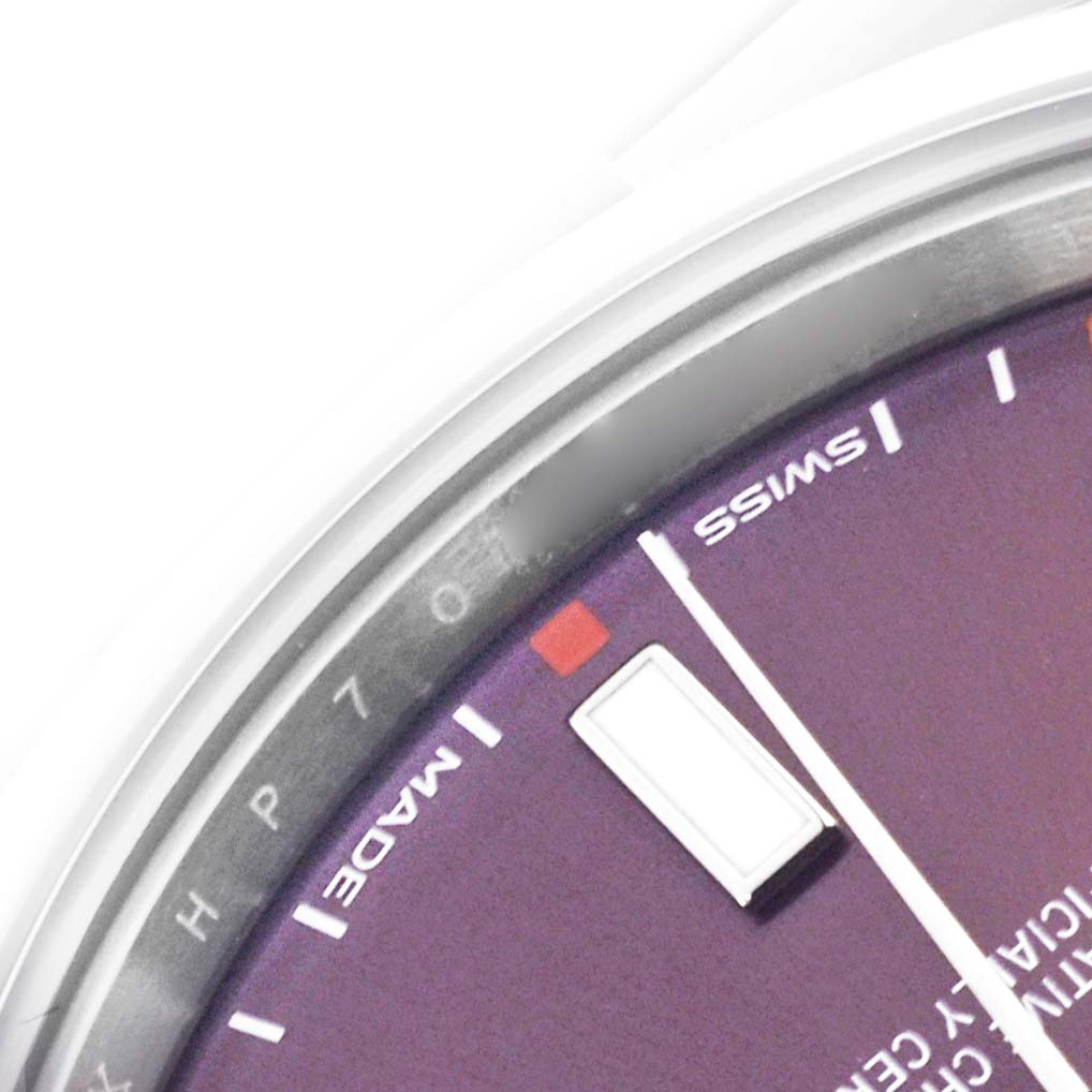 The image shows a close-up of the dial and bezel edge of a Rolex Oyster Perpetual 114300 Men
s Stainless Steel Red Dial 114300 Men
s Stainless Steel Red Dial, focusing on the top section.