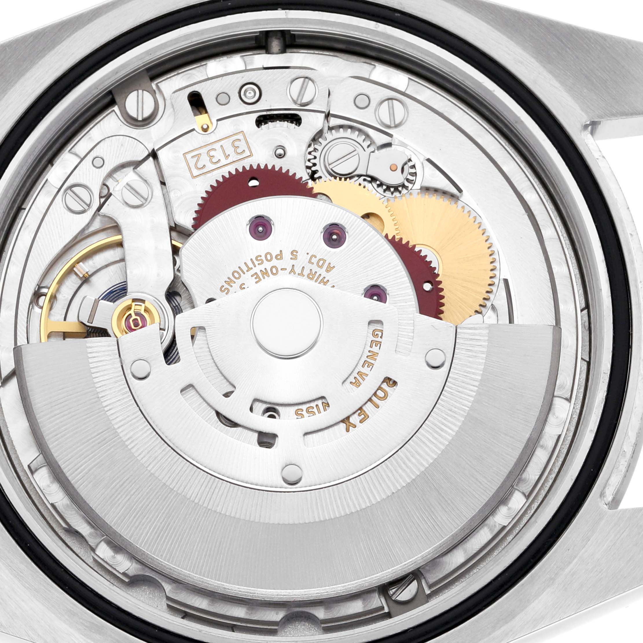 The image shows the internal movement of a Rolex Oyster Perpetual 114300 Men
s Stainless Steel Red Dial 114300 Men
s Stainless Steel Red Dial watch, viewed from the back, highlighting gears and components.