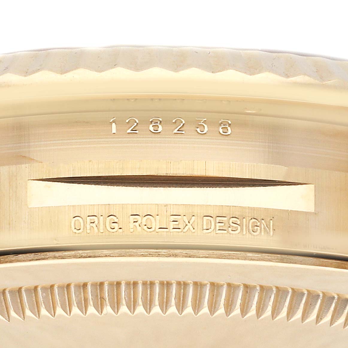 The image shows the bezel and case edge of a Rolex President 128238 Men's Yellow Gold Champagne Dial 128238 Men's Yellow Gold Champagne Dial model with engraving details.
