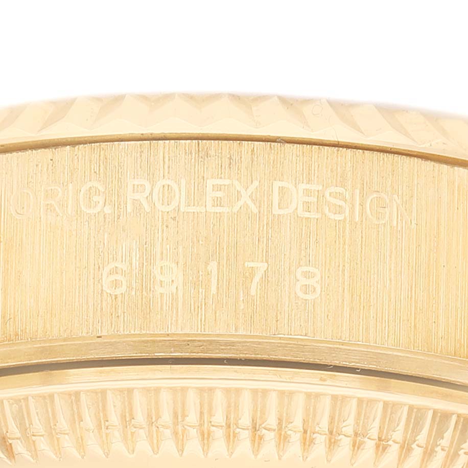 The image shows a close-up of the side of a Rolex President 69178 Women's Yellow Gold Champagne Dial watch, focusing on the bezel and the edge of the case.