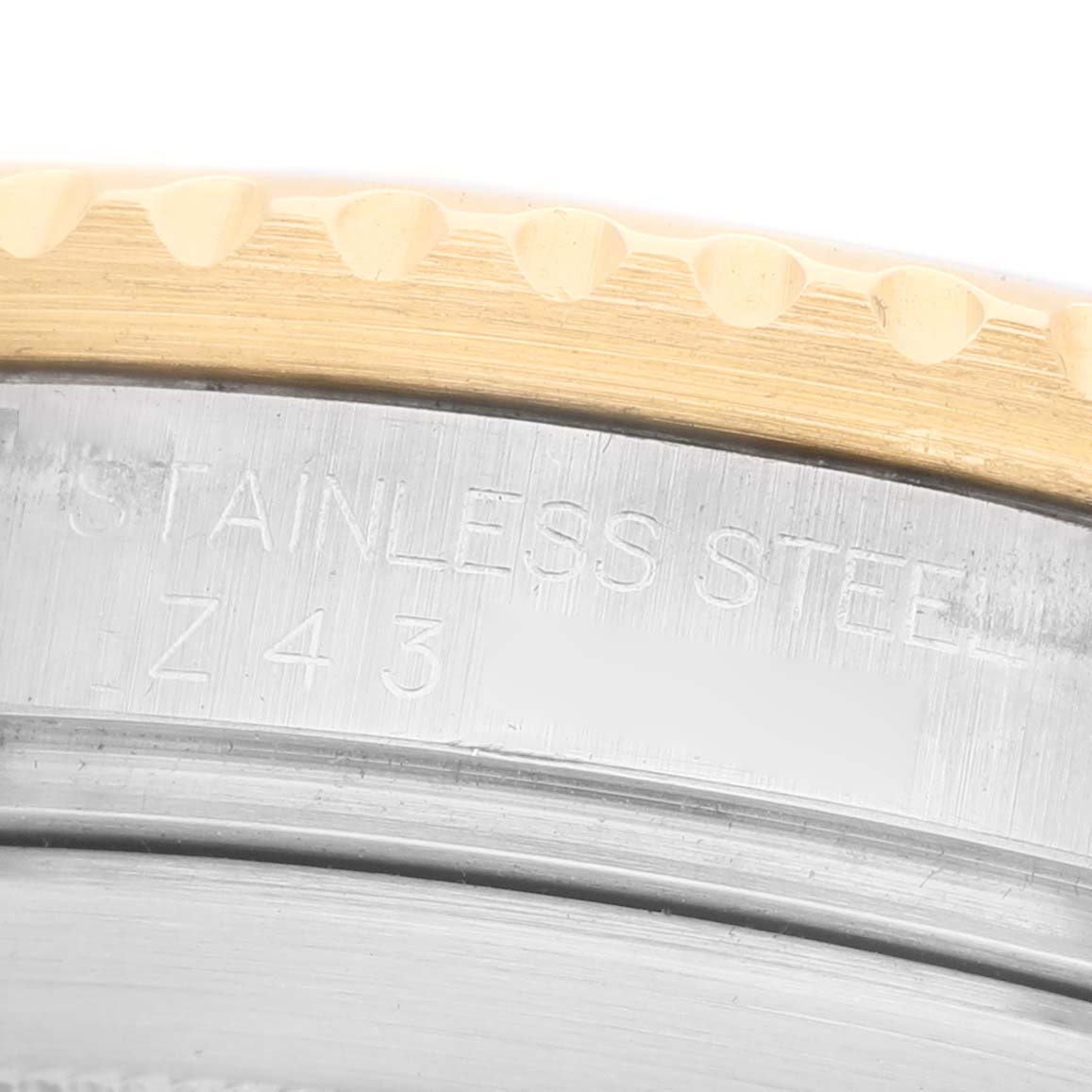 The image shows a close-up of the bezel and case side of a Rolex Submariner 16613 Men's Steel and Gold (two tone) Blue Dial, highlighting the "STAINLESS STEEL" engraving.