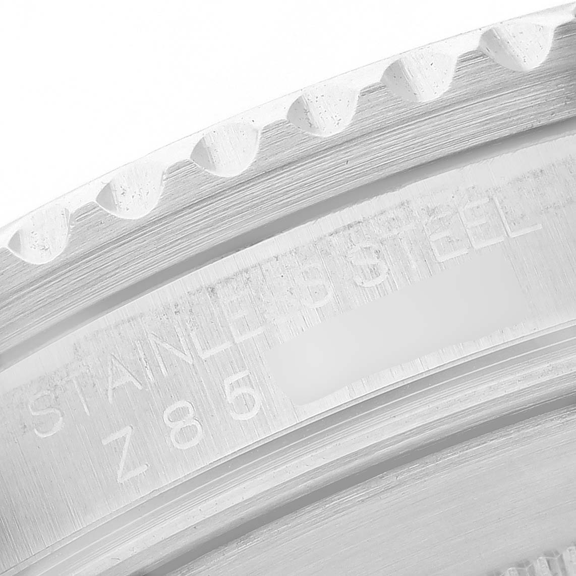 The image shows a close-up angle of the edge and engraved text on the bezel of a Rolex Submariner 16610 Men's Stainless Steel Black Dial watch.