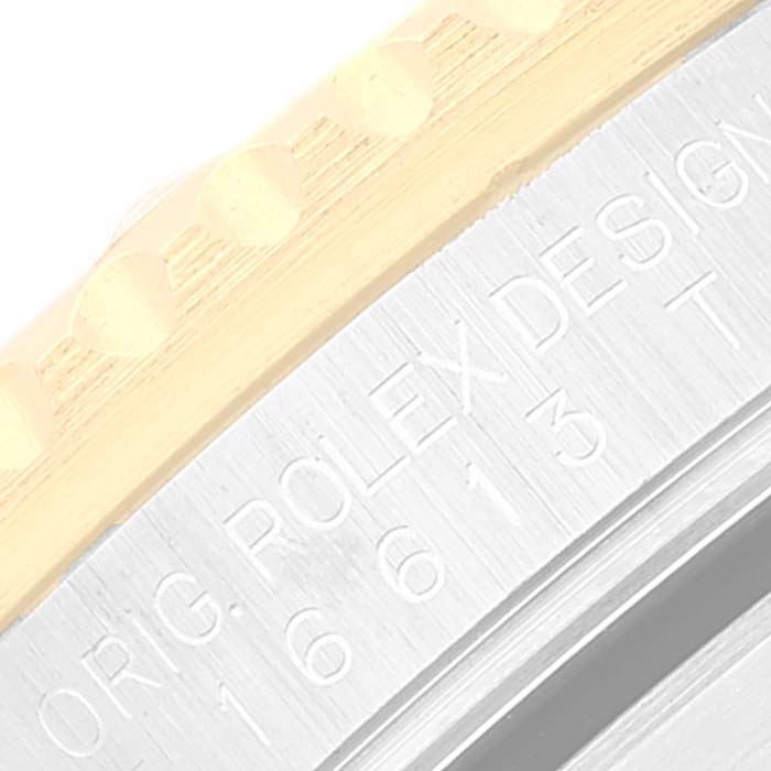 This image shows a close-up of the engraved side of a Rolex Submariner 16613 Men's Steel and Gold (two tone) Black Dial 16613 Men's Steel and Gold (two tone) Black Dial model 16613, highlighting the bezel and serial number.