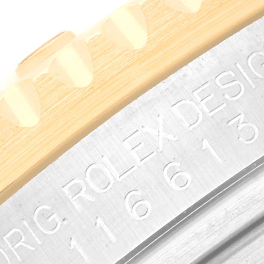 The image shows a close-up of the side of a Rolex Submariner 116613 Men
s Steel and Gold (two tone) Black Dial 116613 Men
s Steel and Gold (two tone) Black Dial watch, highlighting the engraved model number and the edge of the bezel.