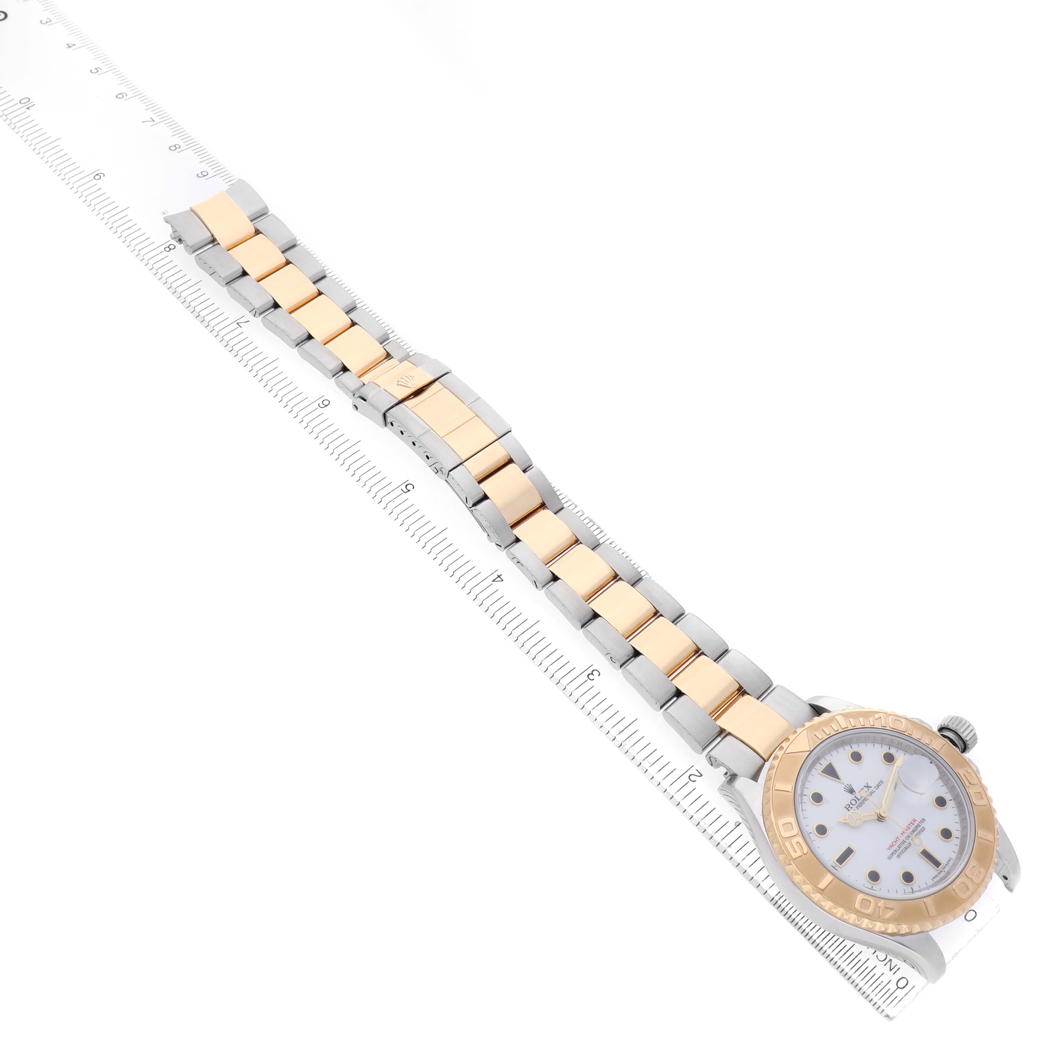 The image shows a top view of a Rolex Yacht-Master 16623 Men's Steel and Gold (two tone) White Dial watch with its full bracelet and bezel visible alongside a ruler.
