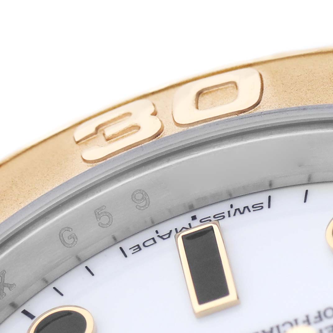 The image shows a close-up of the Rolex Yacht-Master 16623 Men's Steel and Gold (two tone) White Dial watch bezel and part of the dial with indices and markings.
