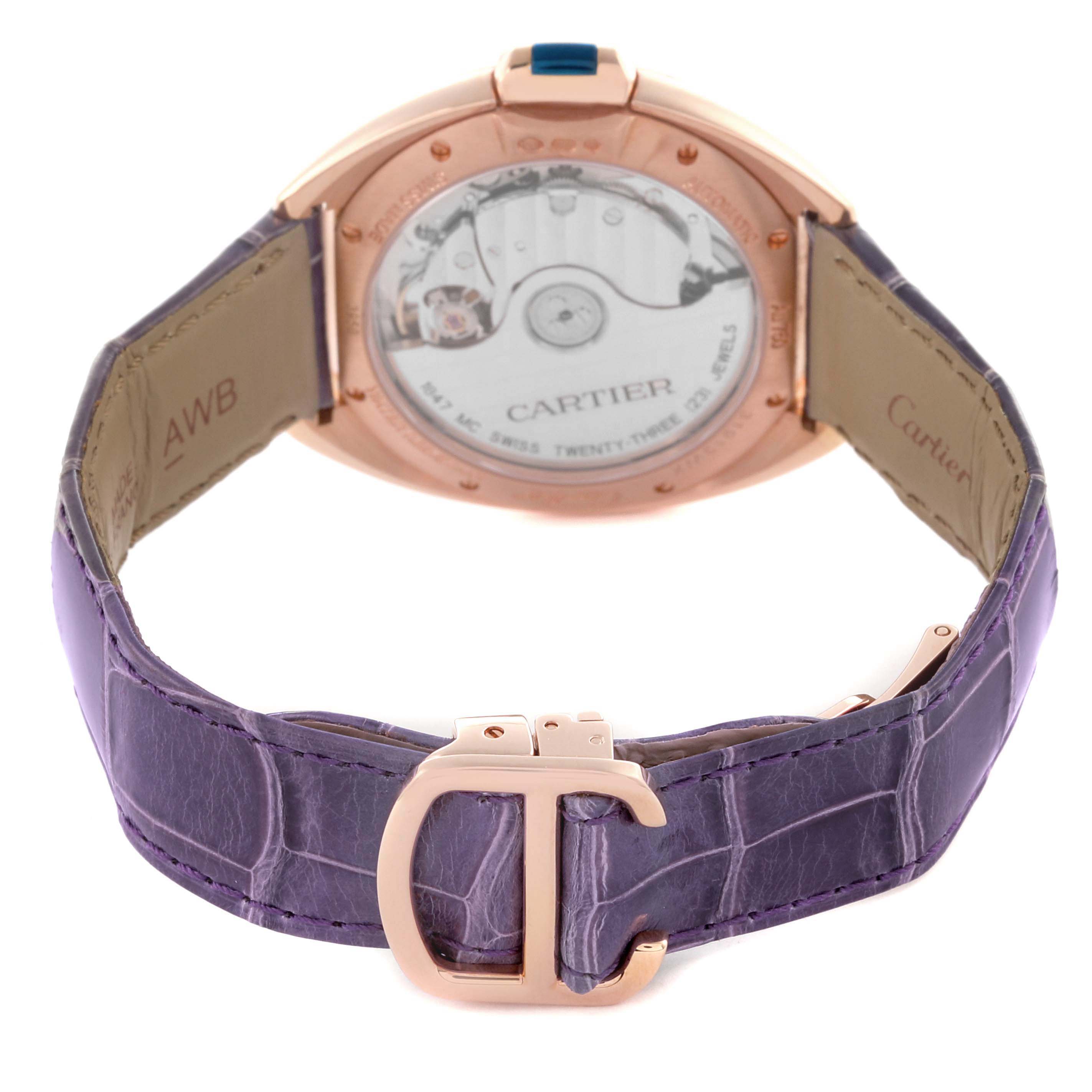 The Cartier Clé watch is shown from the back, highlighting the transparent case back and purple leather strap.