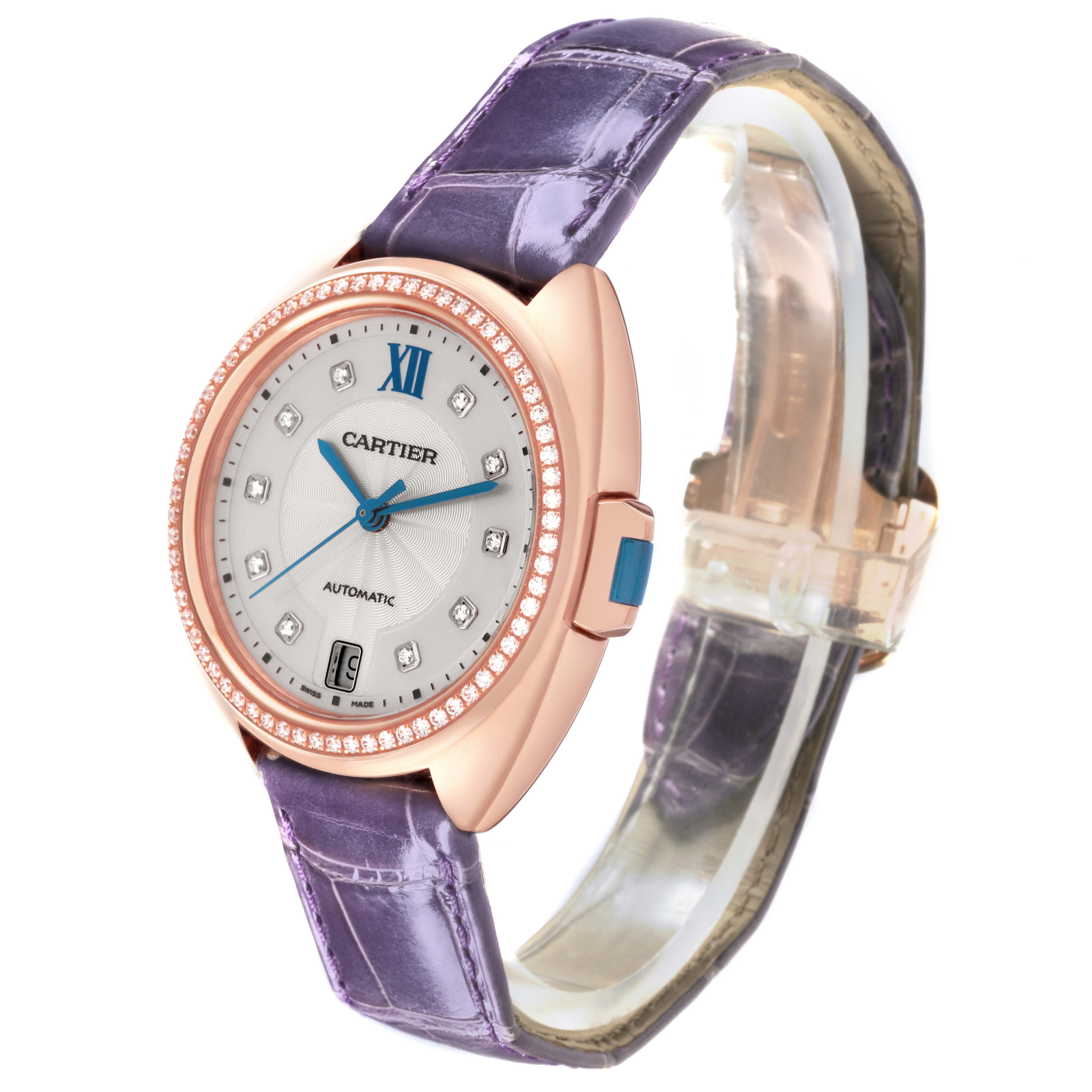 The Cartier Clé watch is shown at an angled view, highlighting its face, purple strap, rose gold casing, and diamond bezel.