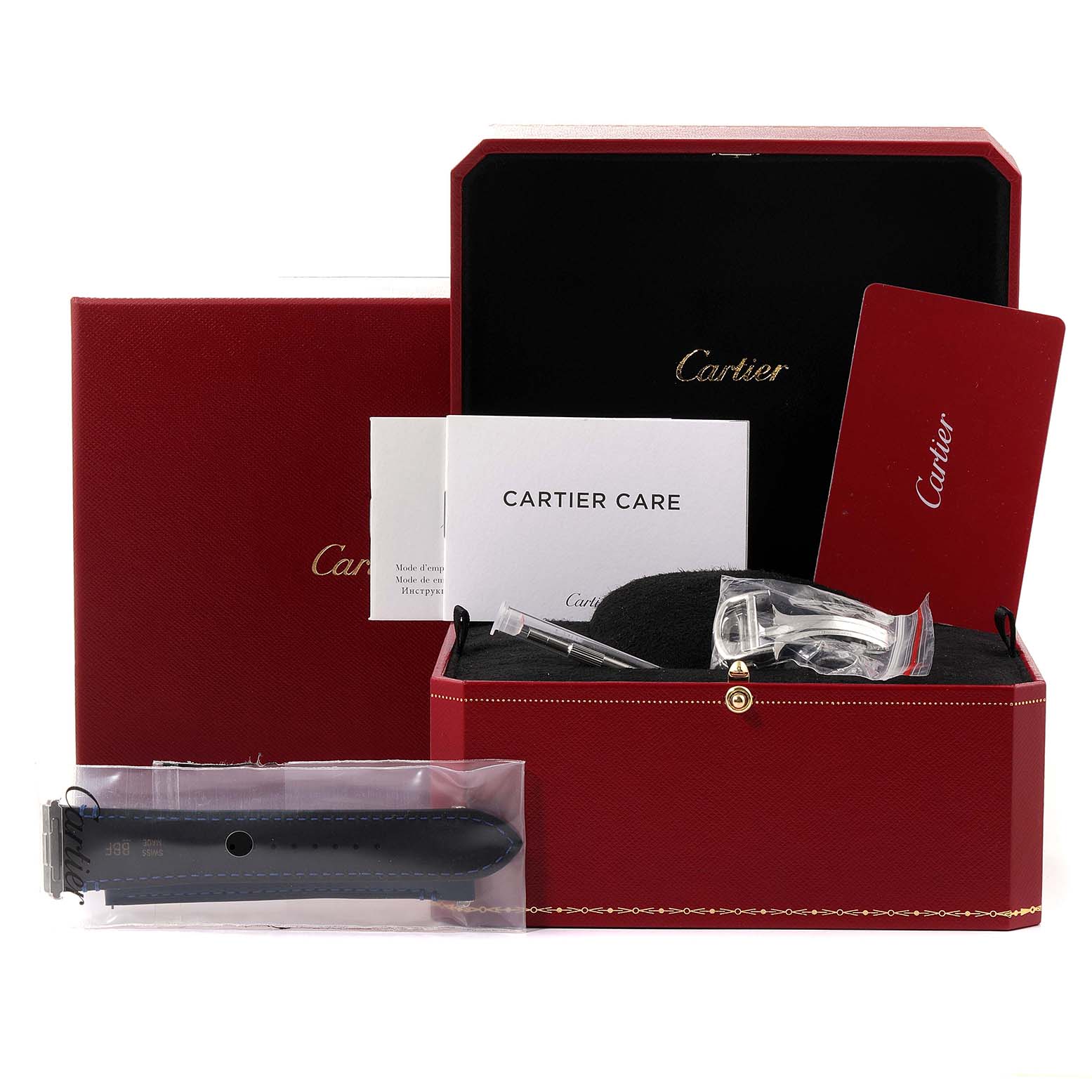 The image shows a Cartier Santos WSSA0030 Men's Stainless Steel Blue Dial WSSA0030 Men's Stainless Steel Blue Dial model watch box with accessories, straps, and documentation arranged in the open box.