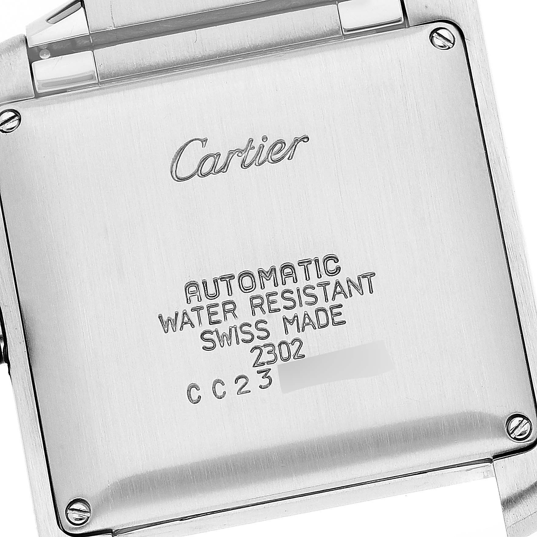 The image shows the backside of a Tank Francaise by Cartier, showcasing its inscriptions and part of the metal strap.