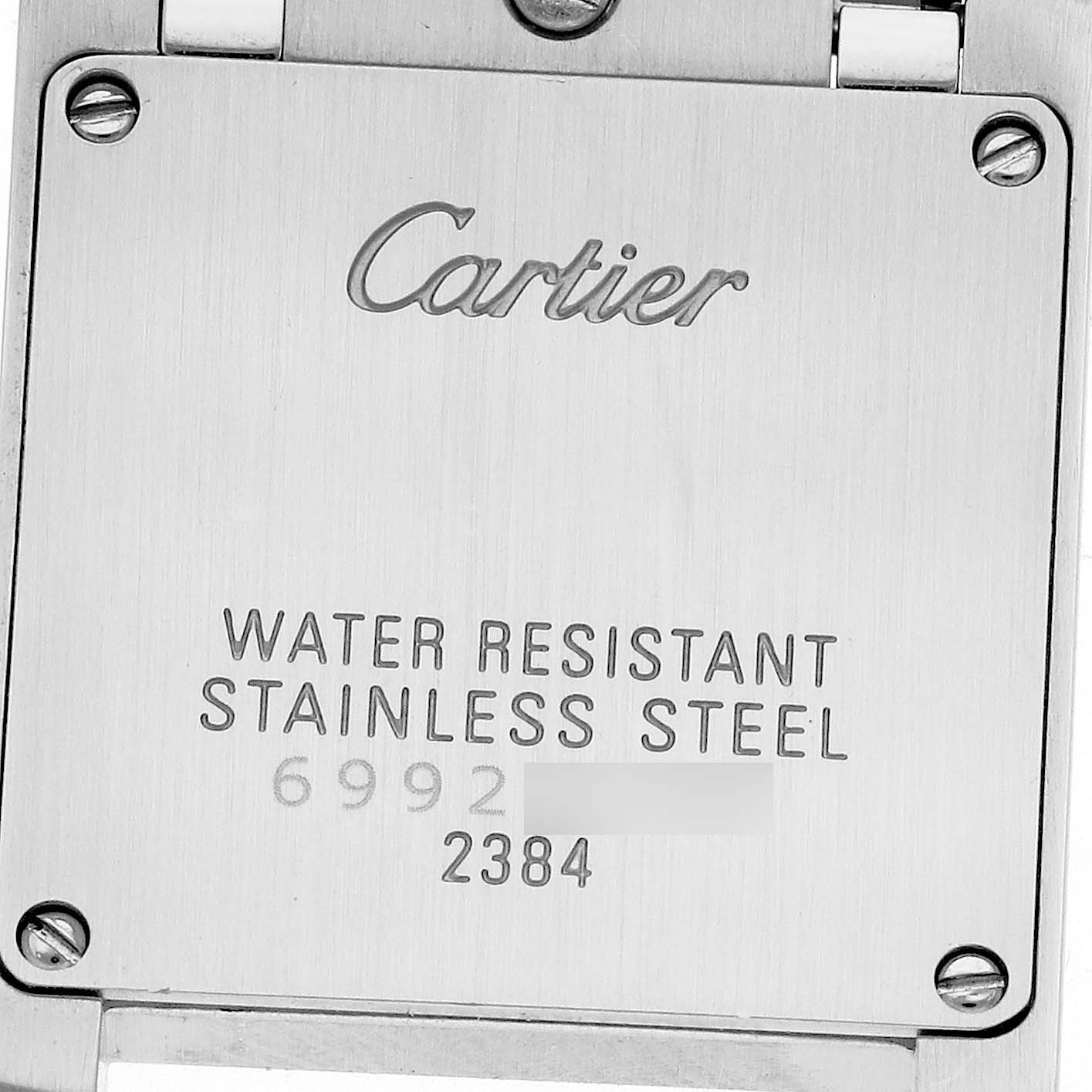 The image shows the back case of a Cartier Tank Francaise W51028Q3 Women's Stainless Steel Mother of Pearl Dial W51028Q3 Women's Stainless Steel Mother of Pearl Dial watch, displaying engravings of the brand, model number, and material.