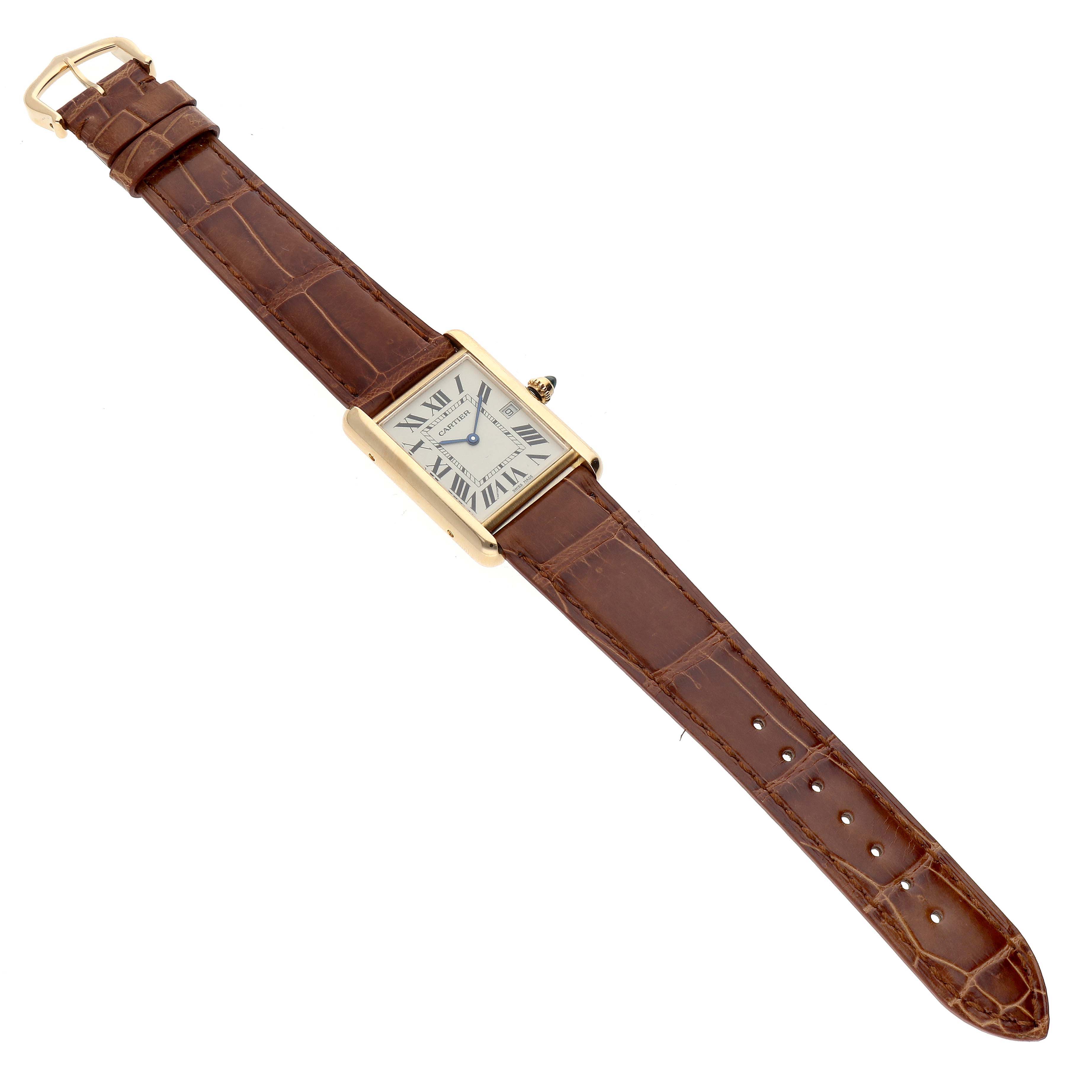 The image shows a Tank Louis model by Cartier viewed from above, showcasing the entire watch with its brown leather strap and rectangular face.